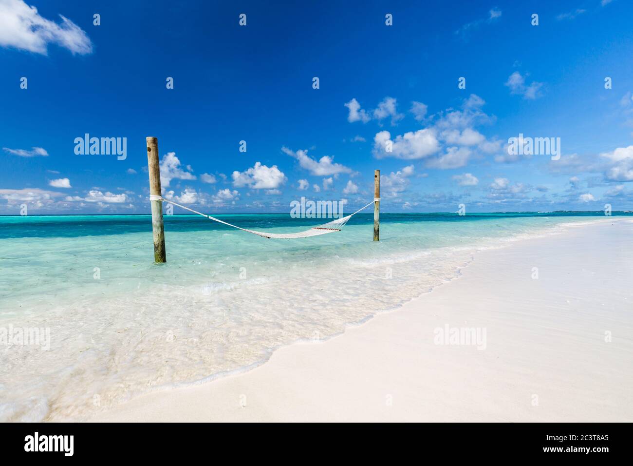 Spiaggia tropicale soleggiata con amaca tradizionale intrecciata esotica. Viaggi estivi di lusso, romantica destinazione di vacanza in coppia, fuga Foto Stock