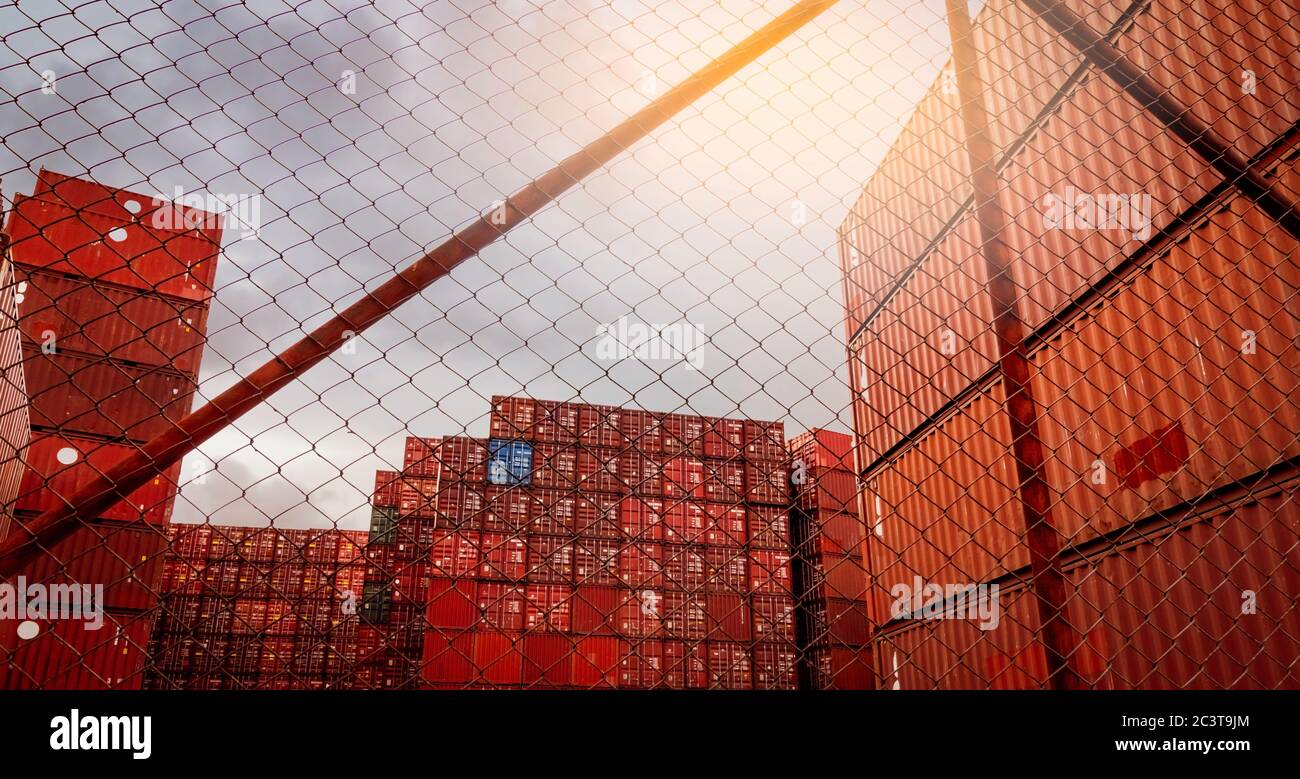 Vista dal recinto del contenitore rosso impilato. Logistica dei container. Carico e spedizione. Attività di logistica di importazione ed esportazione. Stazione di trasporto del contenitore. Foto Stock