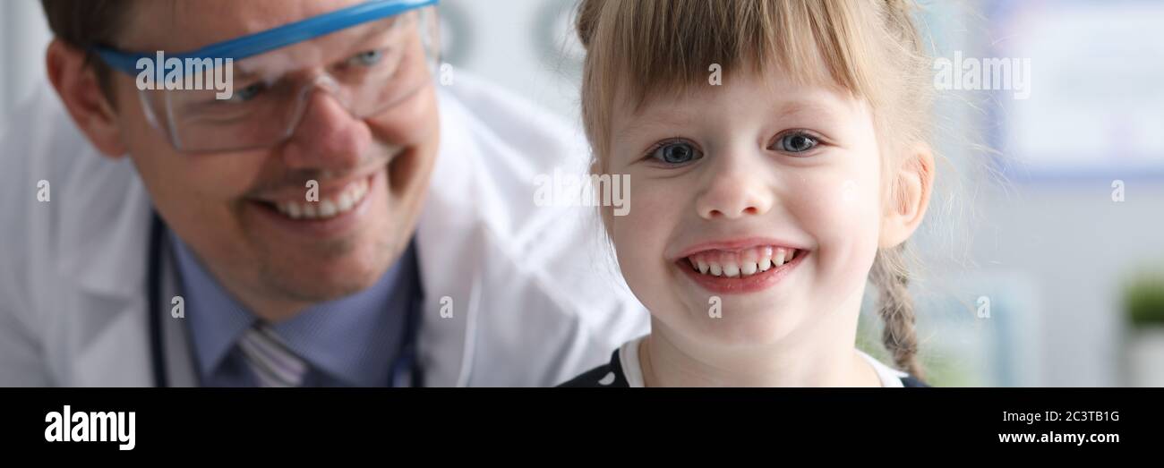 Sorridente medico maschile che guarda sano felice bambino Foto Stock