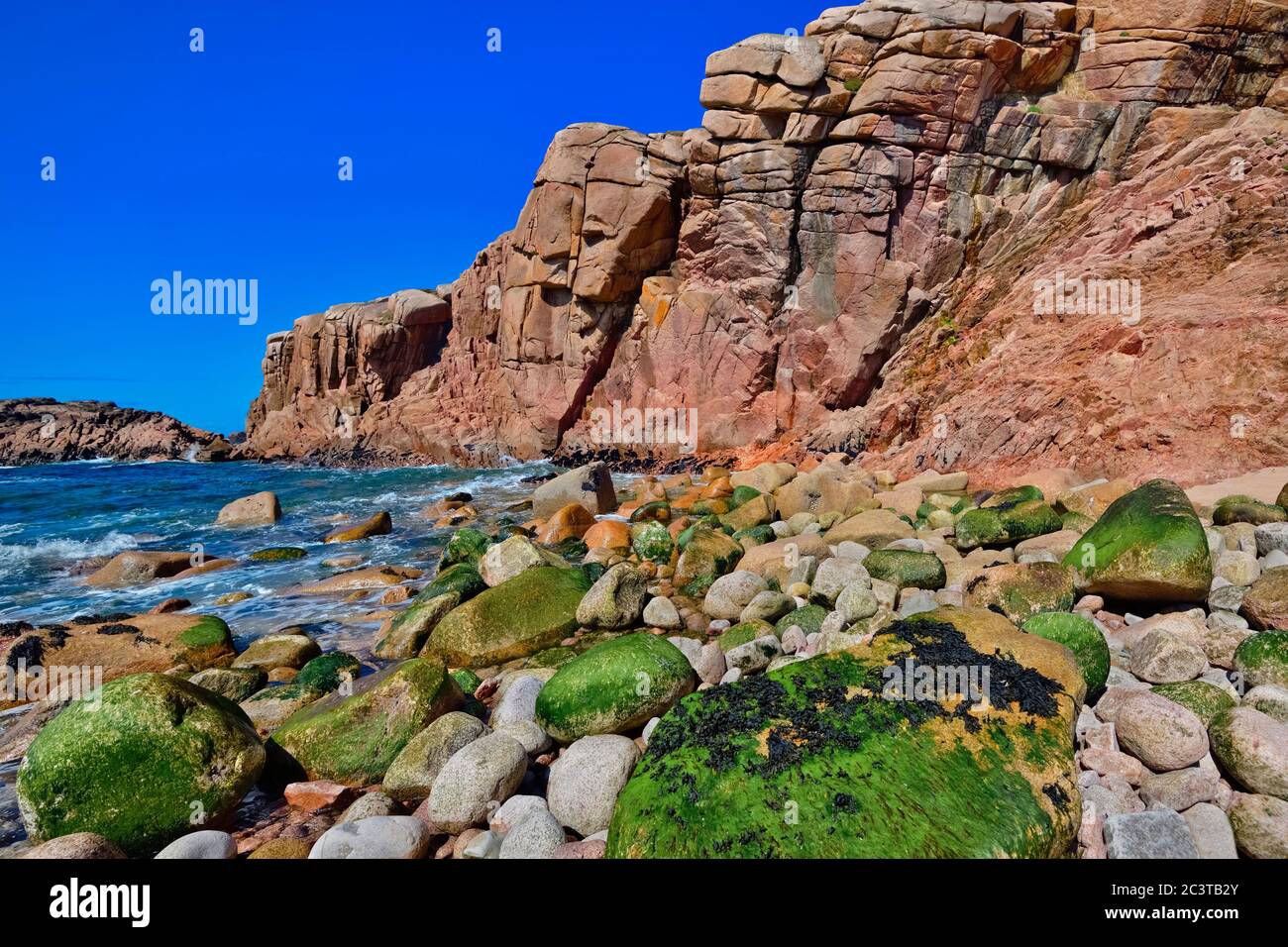 Irlanda, Contea di Donegal, Cruit Island, costa rocciosa con scogliere rosse e mare. Foto Stock