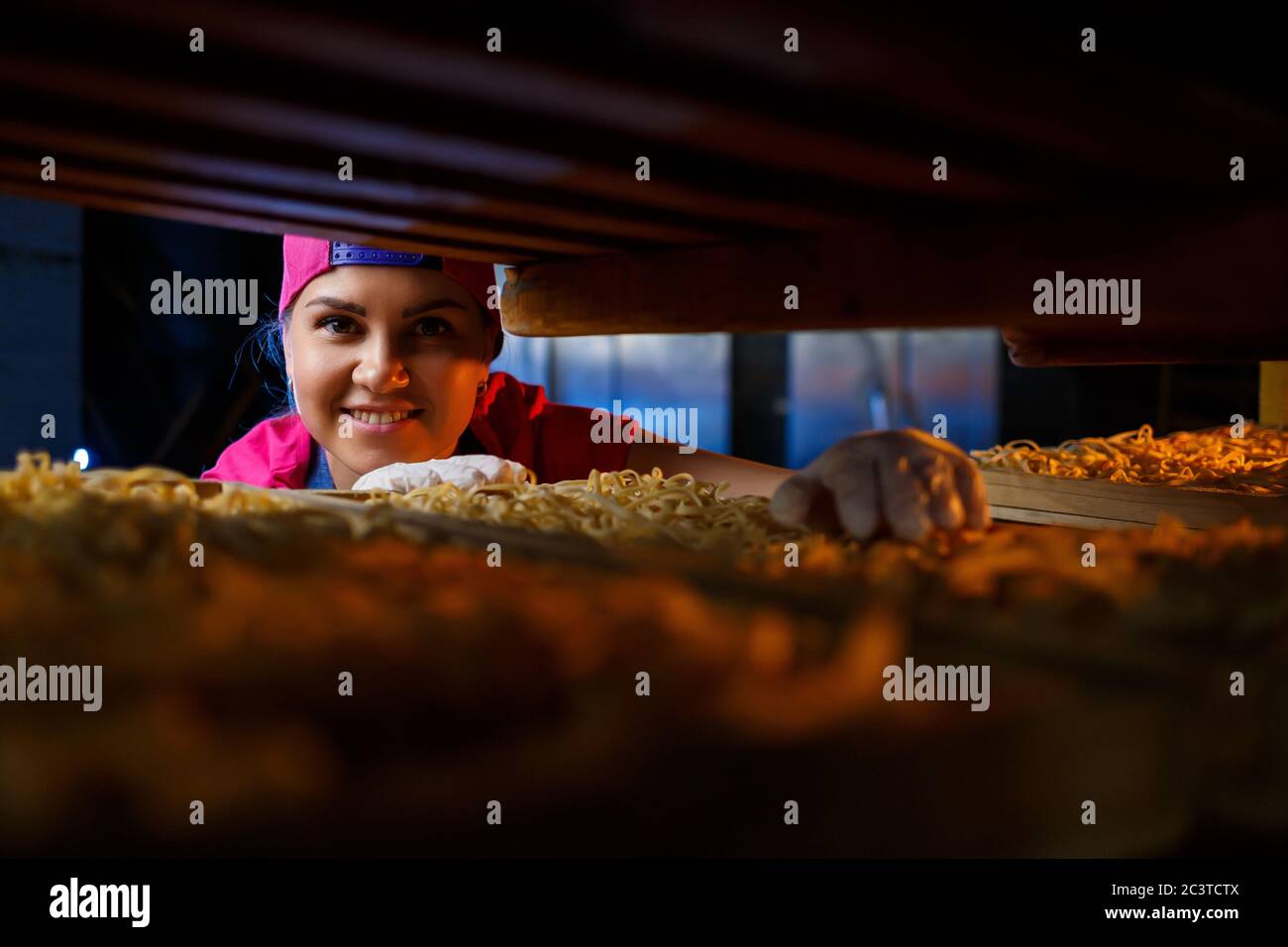 La ragazza lavora sulla produzione di spaghetti. Fare noodle. Pasta. Foto Stock