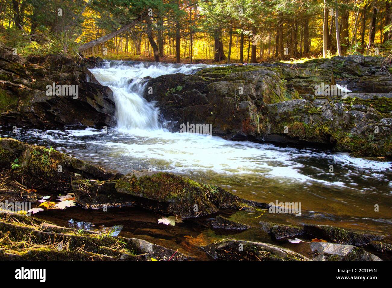 Cascata autunnale con foglie autunnali sul fiume Falls nella piccola città di l'Anse, nella penisola superiore del Michigan. Foto Stock