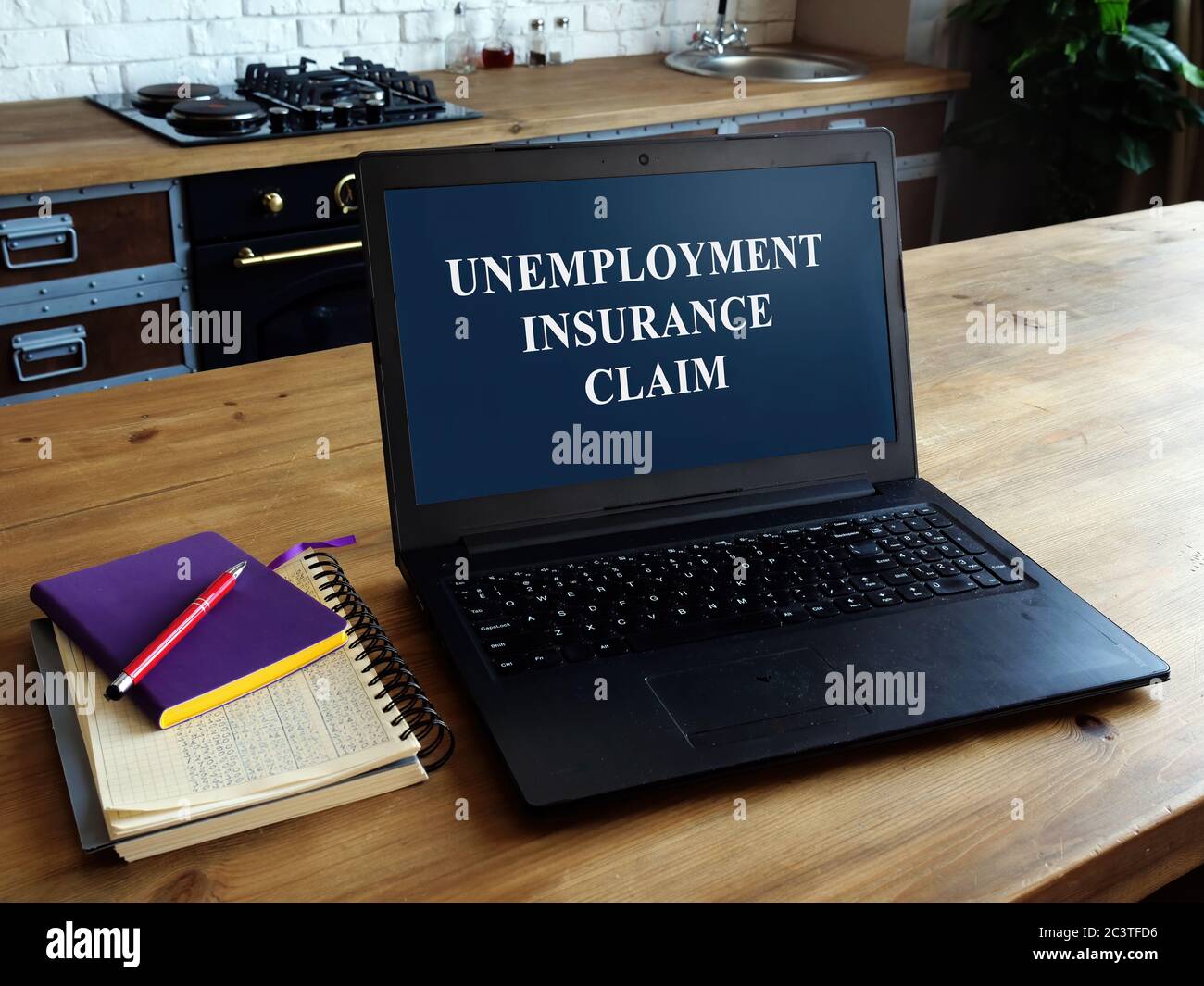 Notebook con assicurazione di disoccupazione aperta su un tavolo in una casa. Foto Stock