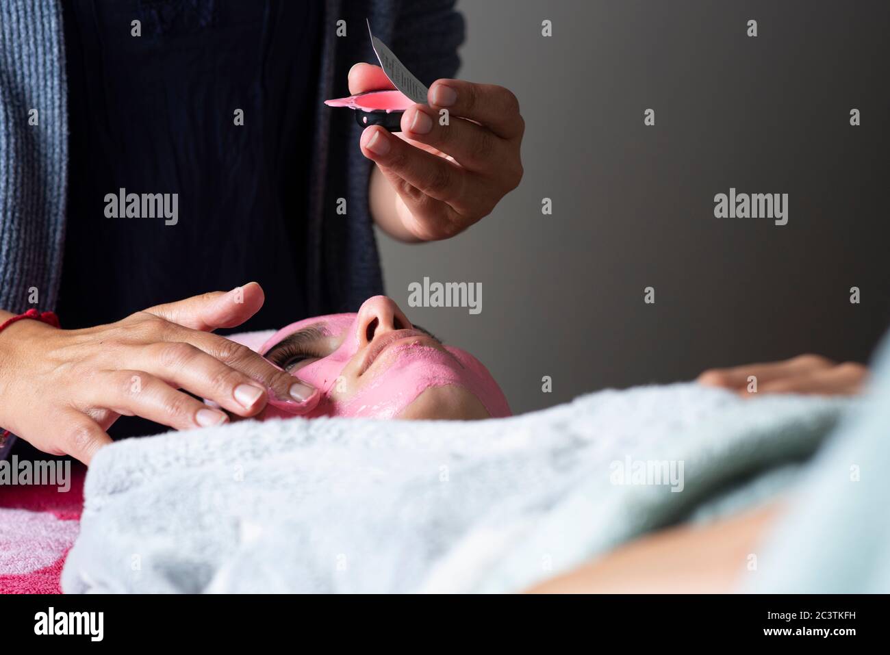 Trattamento di bellezza Lockdown, terapeuta che applica una maschera facciale a casa durante il blocco Covid 19 Foto Stock