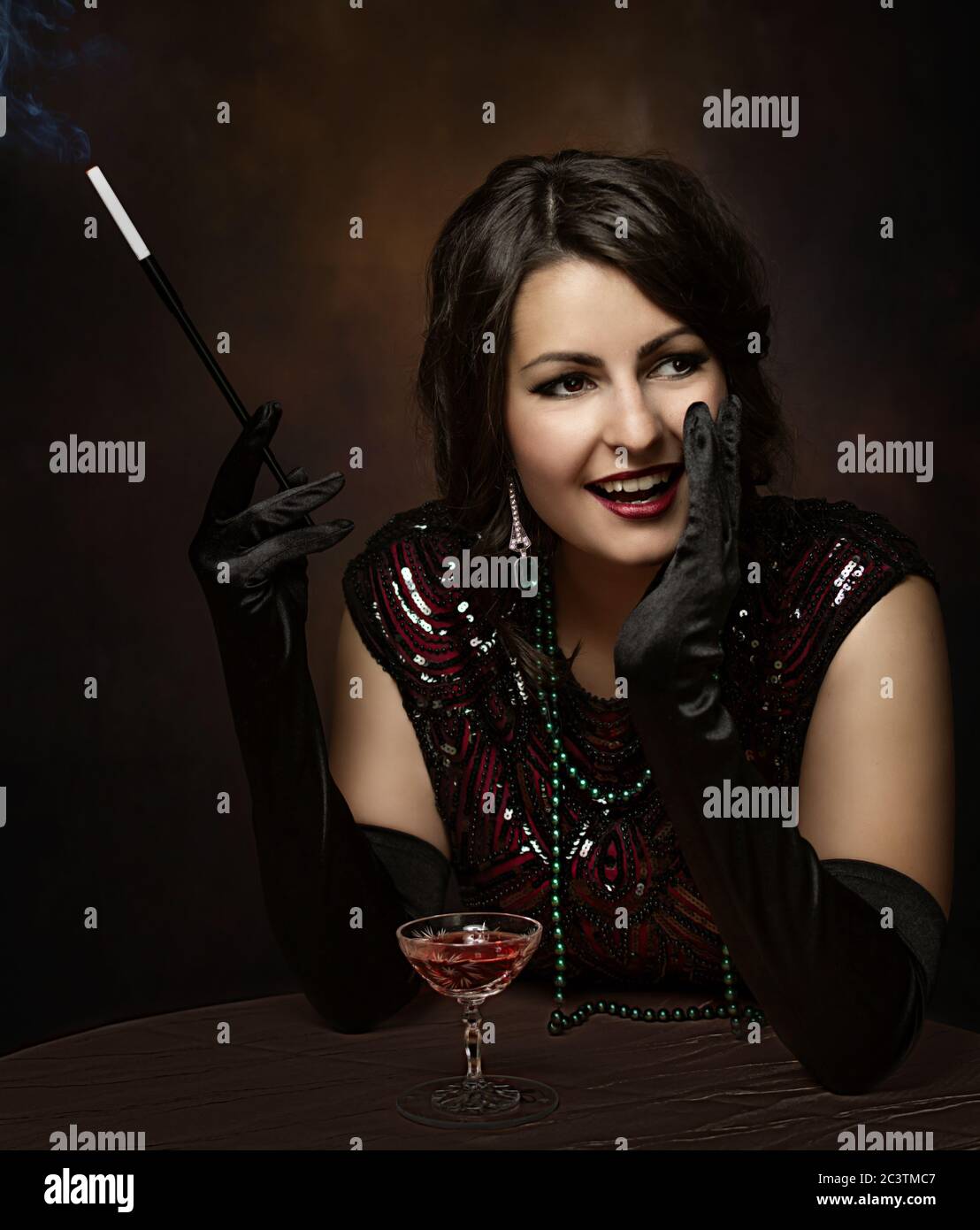 Giovane elegante signora nel suo ventenne d'oro fuma nella vita notturna Foto Stock