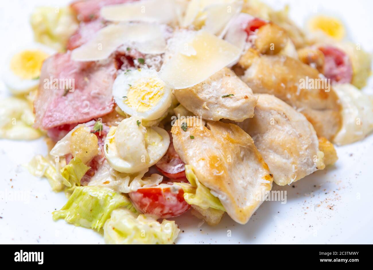 Insalata italiana di caesar con carne di pollo bianca, uova di qual bollite, formaggio parmigiano e carne di pancetta cucinata per pranzo al ristorante. Delizioso cibo naturale pre Foto Stock