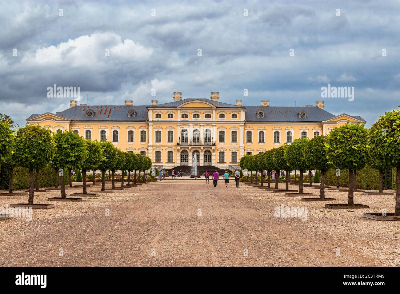 Vicolo centrale nel giardino del Palazzo Rundale che conduce al Palazzo con persone che camminano verso l'edificio. Foto Stock