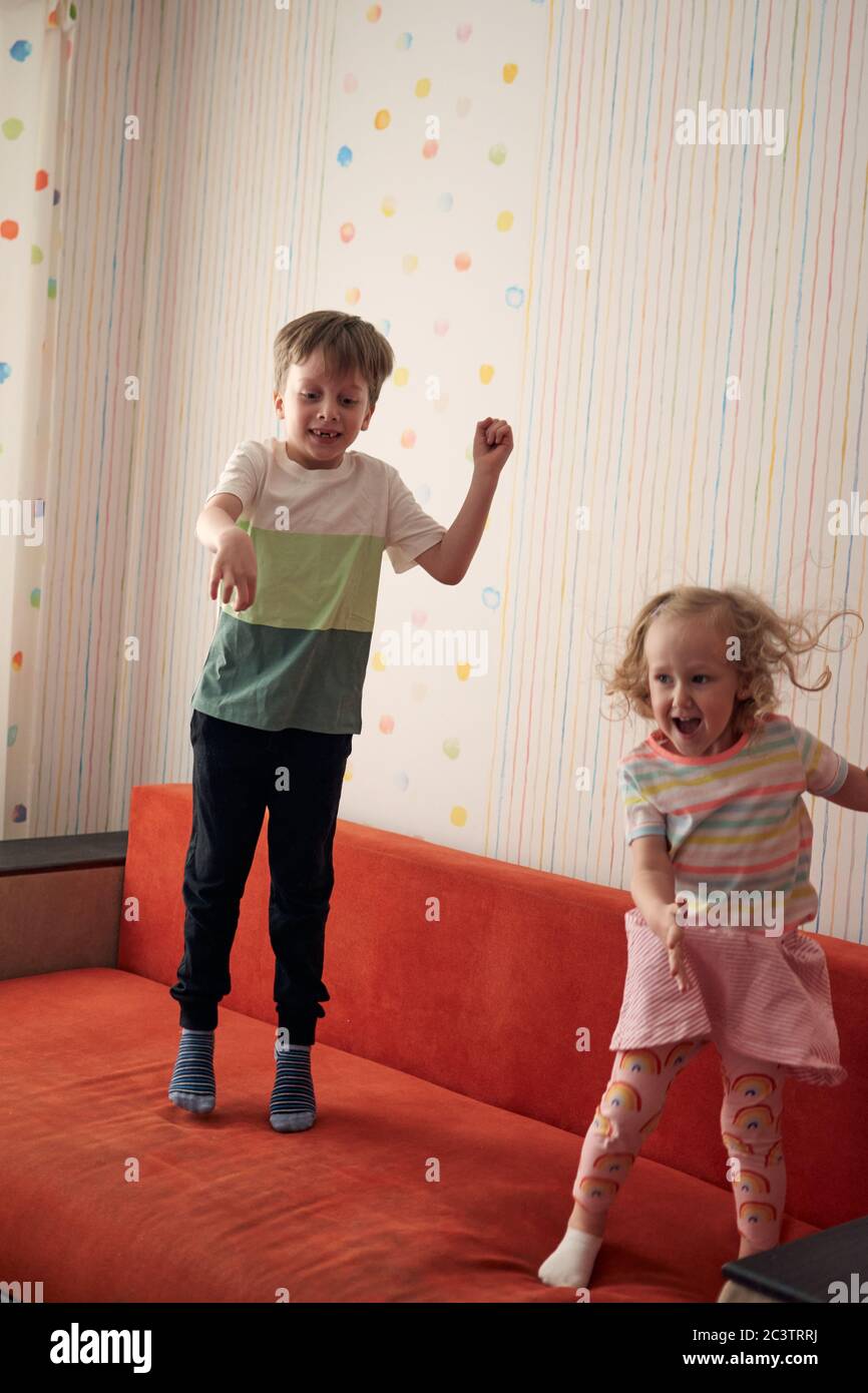 Due bambini felici, ragazzo e ragazza, hanno una lotta cuscino a casa. Divertimento per tutta la famiglia. Quarantine covid-19 e chiuso la scuola durante l'epidemia di coronavirus. Foto Stock