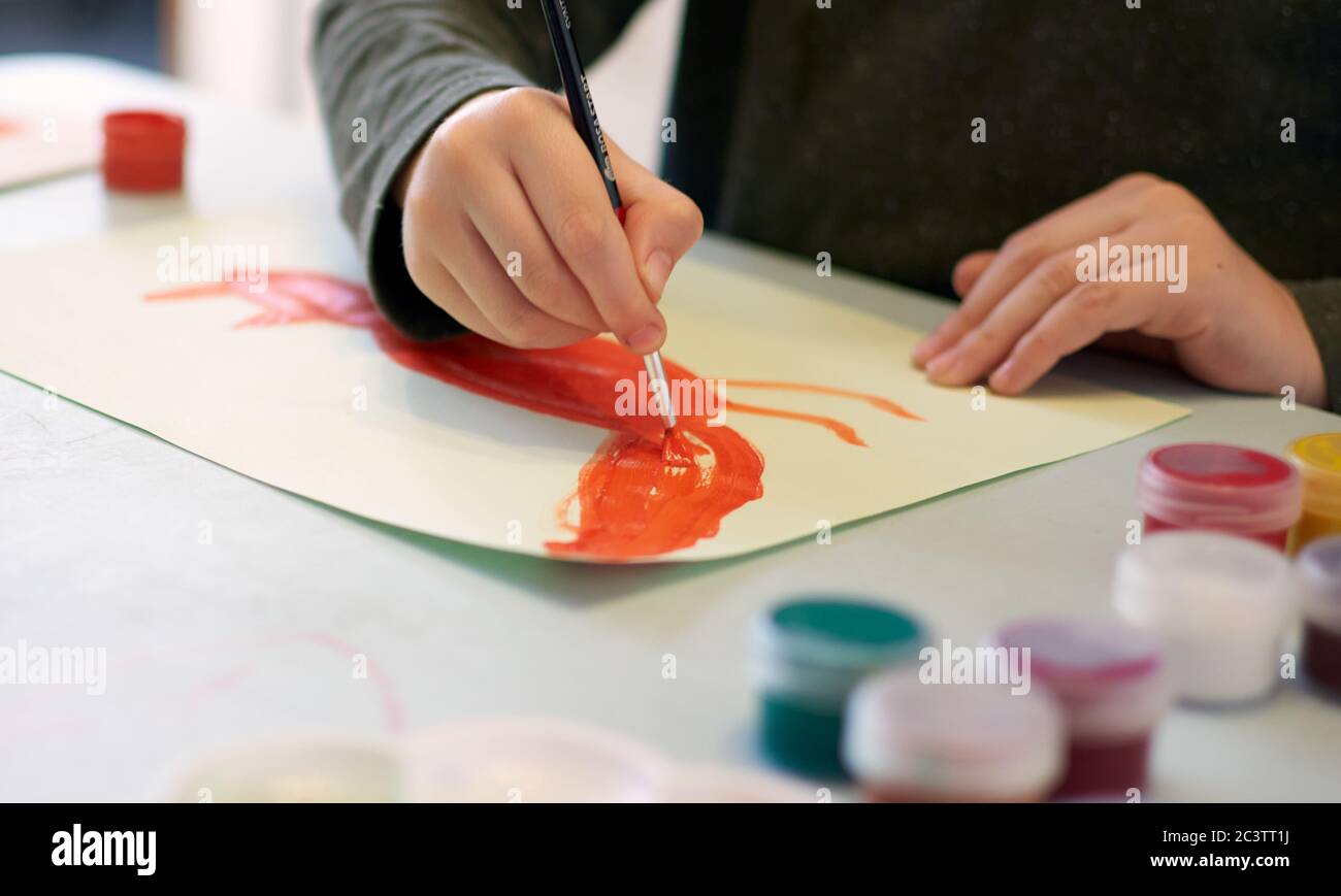 Bambino annuce una foto durante la lezione di arte on-line al telefono cellulare, distanza sociale durante la quarantena Covid-19 Foto Stock