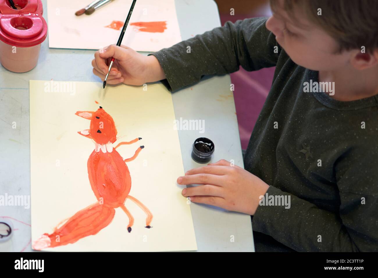 Bambino annuce una foto durante la lezione di arte on-line al telefono cellulare, distanza sociale durante la quarantena Covid-19 Foto Stock