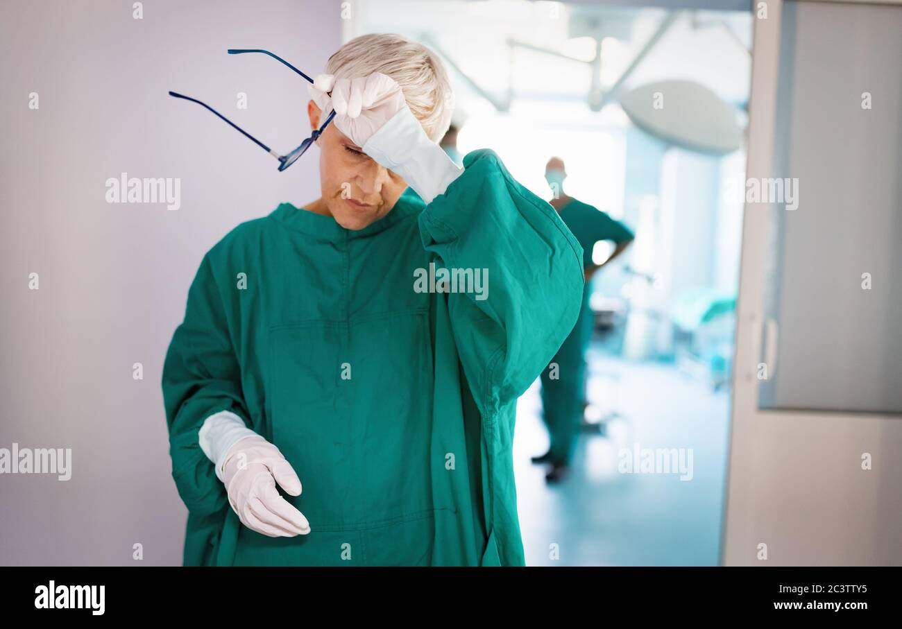 Chirurgo senior dopo che ha fallito un'operazione. Stanco, overlavored, persone, concetto di ospedale. Foto Stock