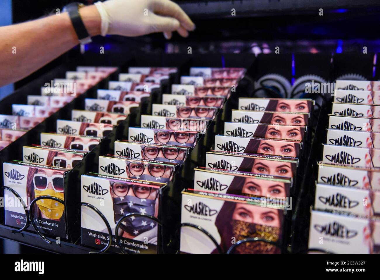 Londra, Regno Unito. 22 giugno 2020. Un membro dello staff carica un distributore automatico in Carnaby Street vendendo al pubblico facemasks dalla società con sede a Londra Maskey. Fondata dall'entreur Adam Freeman per affrontare la domanda di maschere UK-made a prezzi accessibili durante la pandemia di coronavirus in corso, la società di nuova costituzione sta installando i primi distributori automatici di maschere facciali alla moda del Regno Unito in luoghi intorno a Londra, con piani per espandersi ulteriormente. Il 10% del profitto di ogni vendita di facemask viene donato a un ente benefico che sostiene il NHS. Credit: Stephen Chung / Alamy Live News Foto Stock