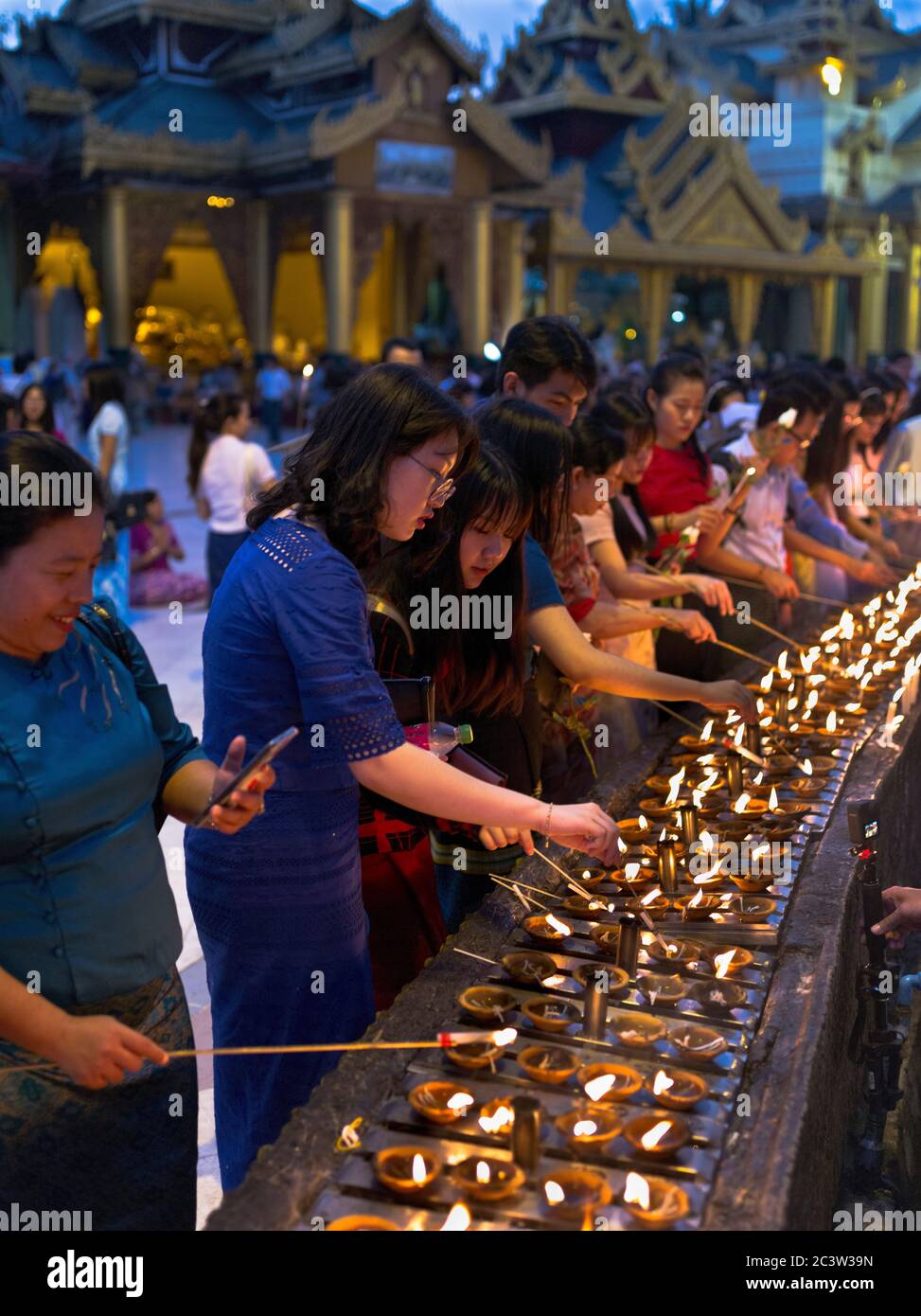 dh Shwedagon Pagoda tempio YANGON MYANMAR buddista candele di illuminazione persone turista rituale culturale illuminazione rituali tradizionali cerimonia femminile Foto Stock