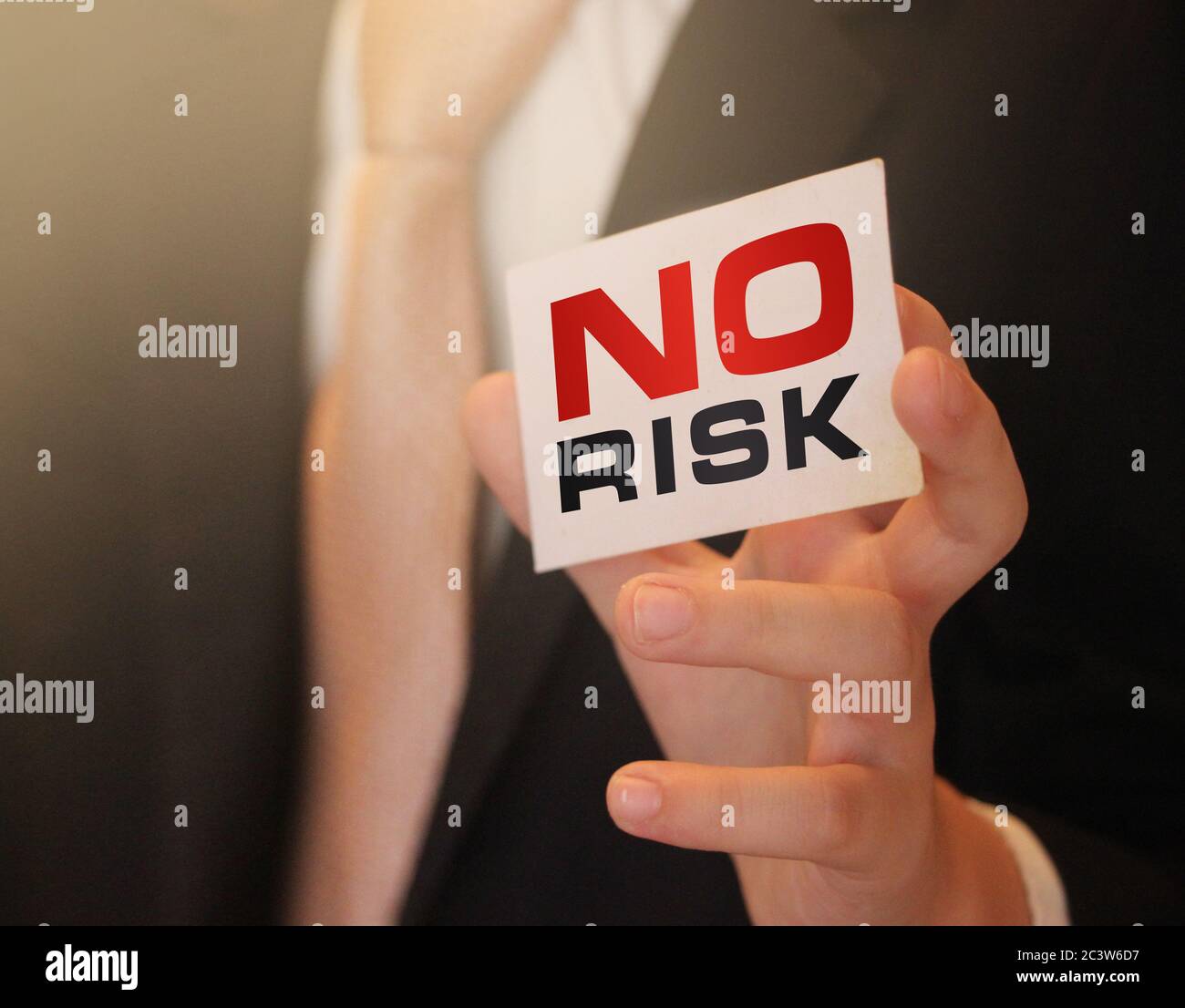 Nessuna parola di rischio su una carta in mano di uomo d'affari. Investimento sicuro con concetto di business a basso rischio Foto Stock