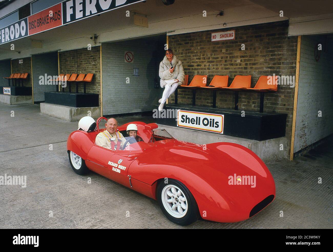 Sir Stirling Moss e la sua famiglia provano la sua auto da corsa sportiva WiDi 1962 al circuito di Donnington Park 1988, con suo figlio Elliot e la moglie Susie. Foto Stock