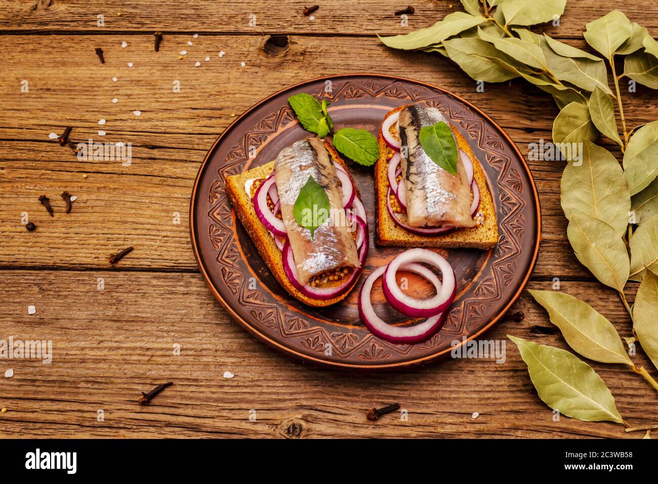Tradizionale norvegese o danese smorrebrod. Sandwich di aringhe, concetto di alimentazione sana. Sfondo in legno, spazio per la copia Foto Stock
