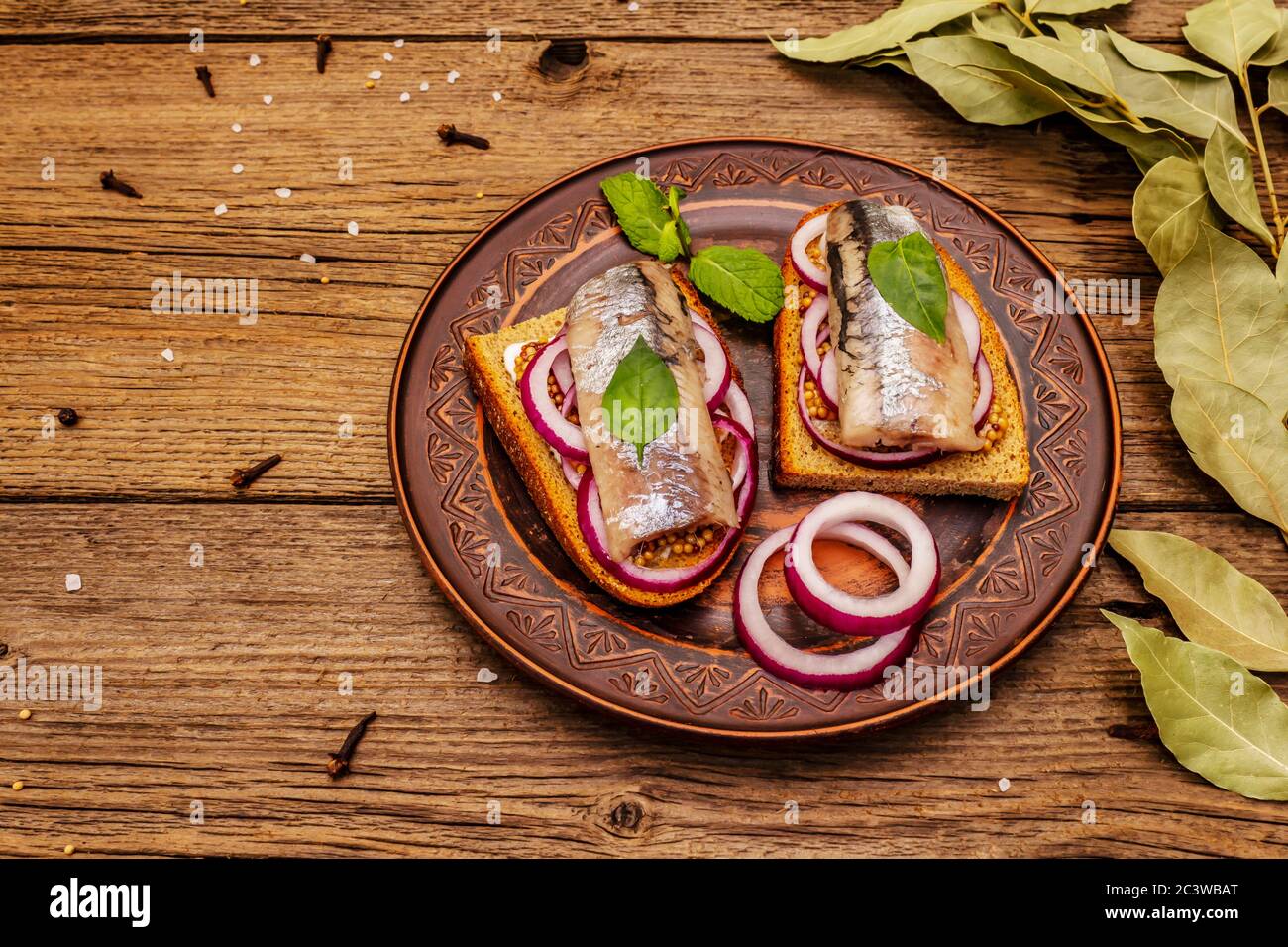 Tradizionale norvegese o danese smorrebrod. Sandwich di aringhe, concetto di alimentazione sana. Sfondo in legno, spazio per la copia Foto Stock