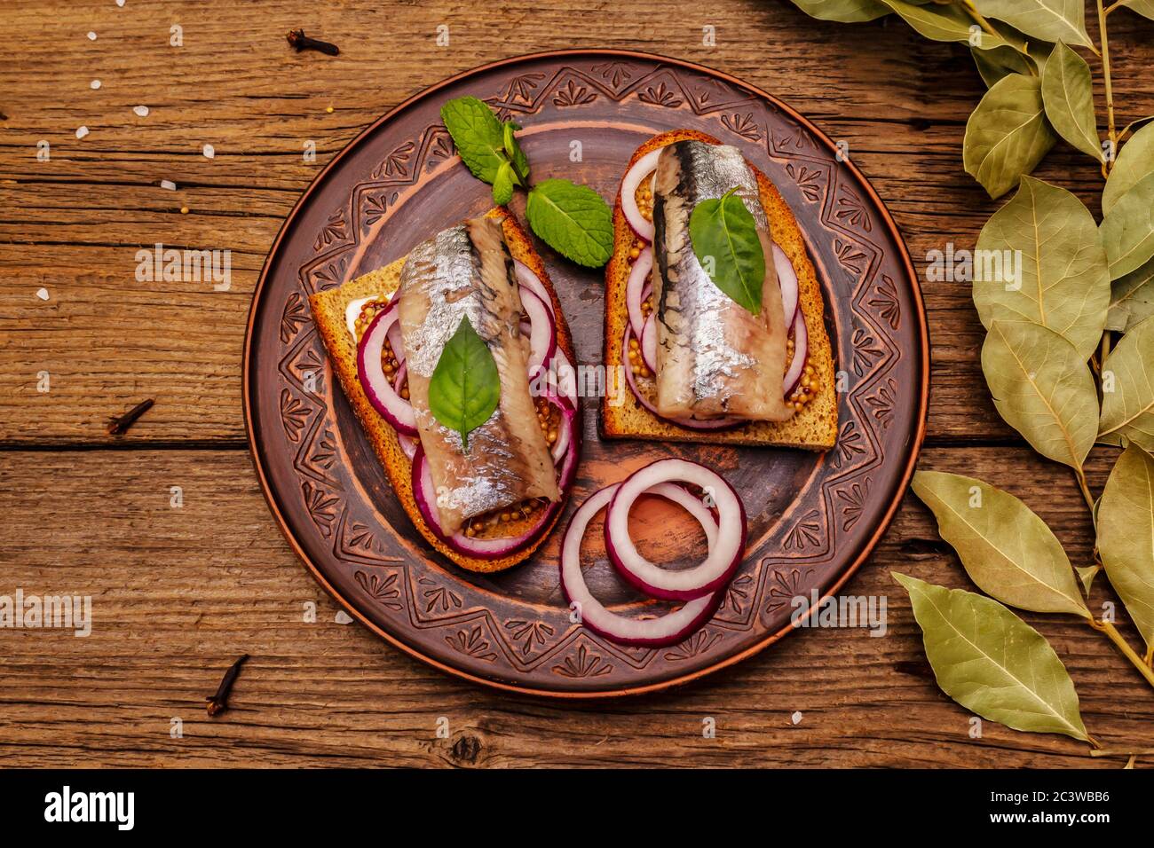Tradizionale norvegese o danese smorrebrod. Sandwich di aringhe, concetto di alimentazione sana. Sfondo in legno, vista dall'alto Foto Stock