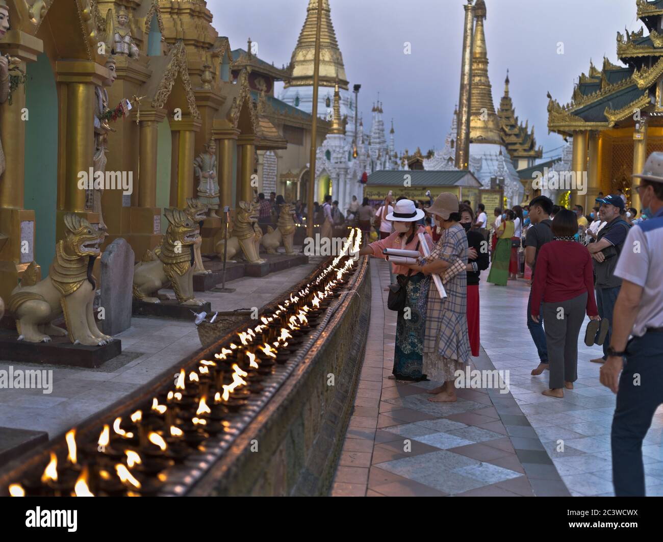 dh Shwedagon Pagoda tempio YANGON MYANMAR ASIA templi buddisti turisti candela di illuminazione persone candele rituali turistici cerimonia di luce tradizionale Foto Stock