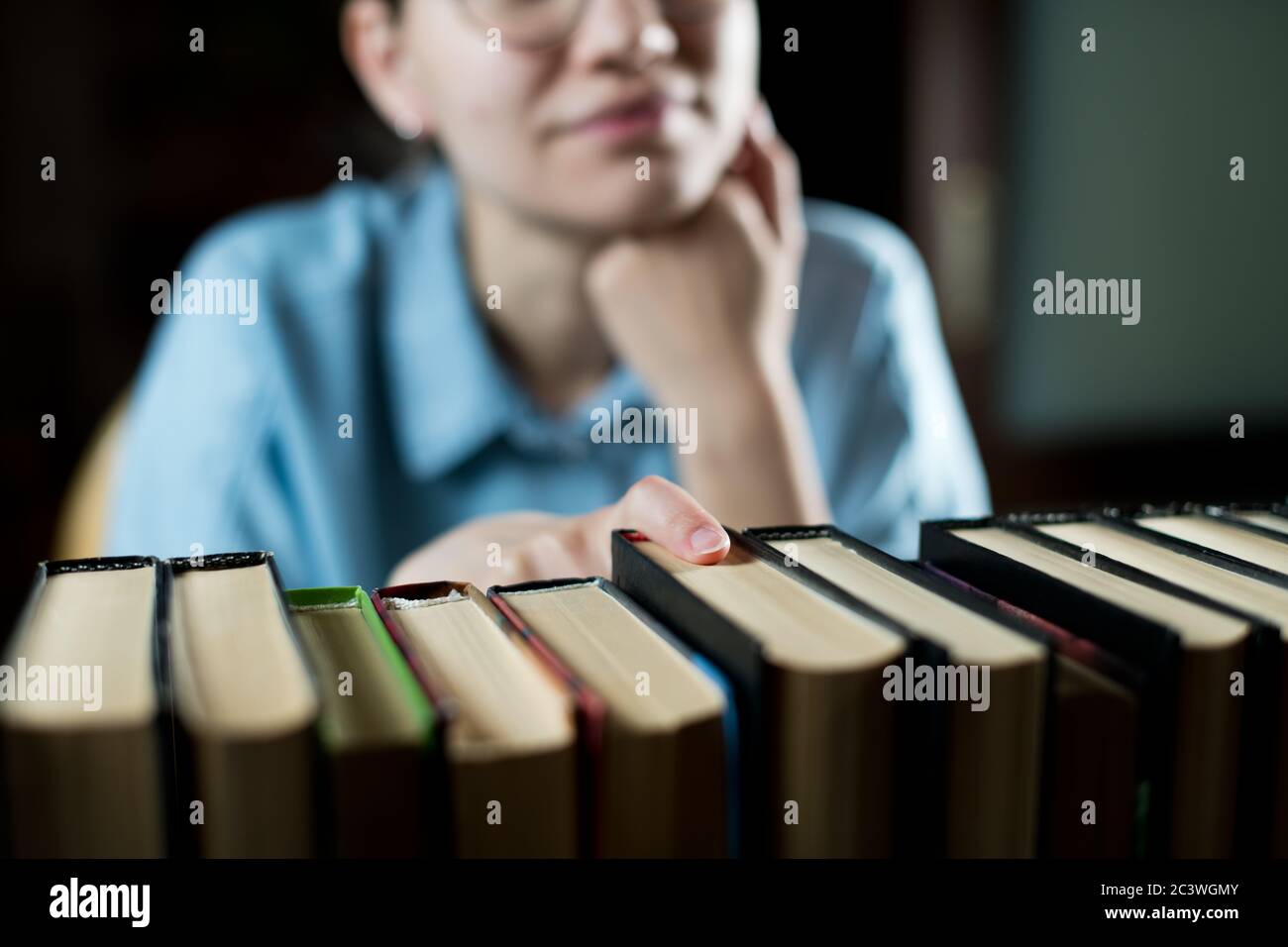 Ragazza sceglie un libro da leggere, fuoco selettivo Foto Stock