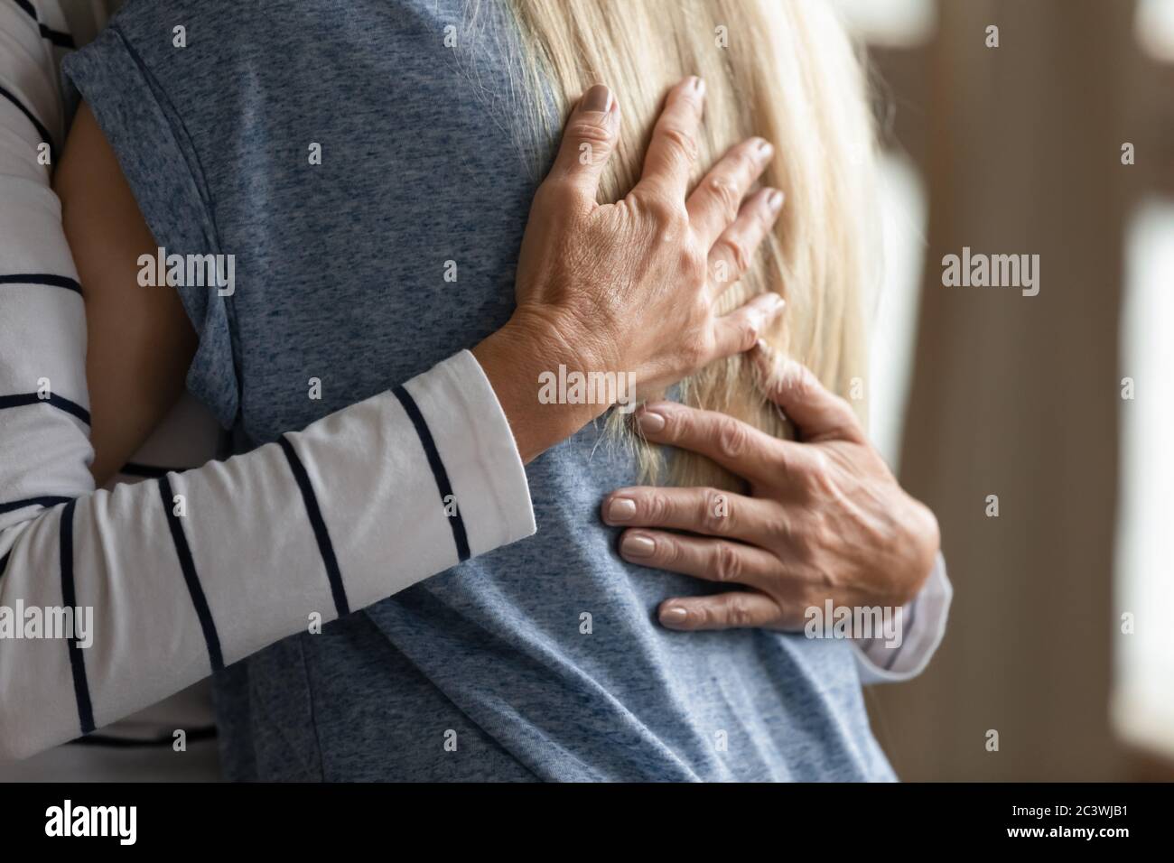 Primo piano immagine ritagliata anziana madre abbracci grunnup figlia Foto Stock
