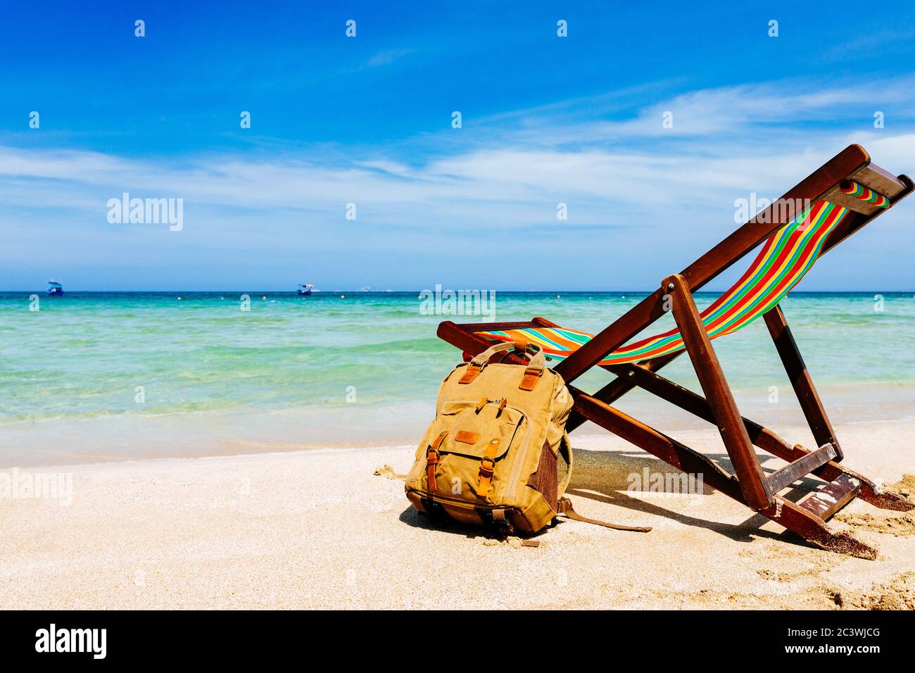 Una sedia a sdraio sulla spiaggia sabbiosa di una spiaggia tropicale  affacciata sul mare aperto. Uno