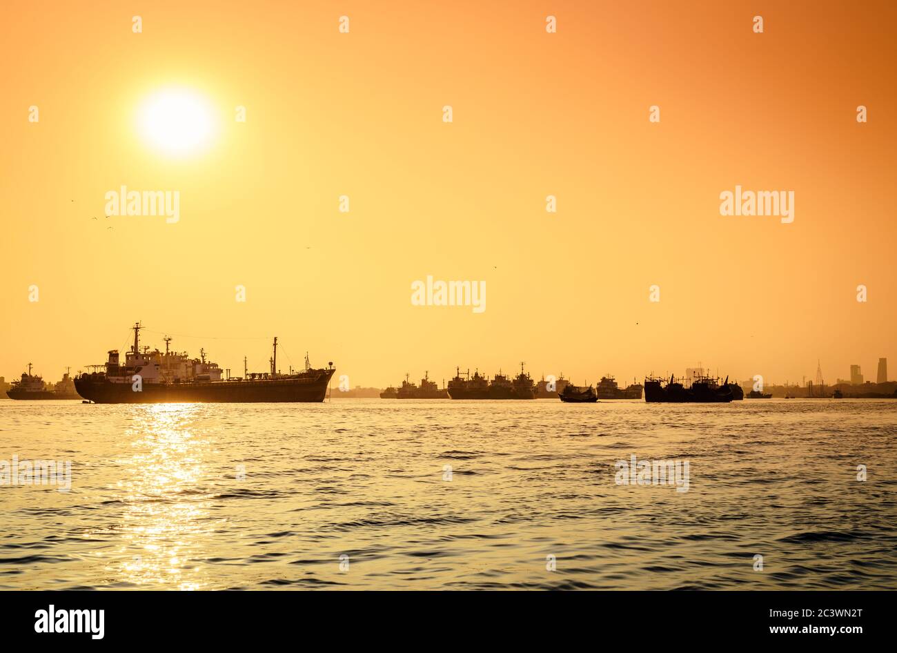 Navi commerciali su ancoraggio nel fiume Karnafuli in Bangladesh al tramonto Foto Stock