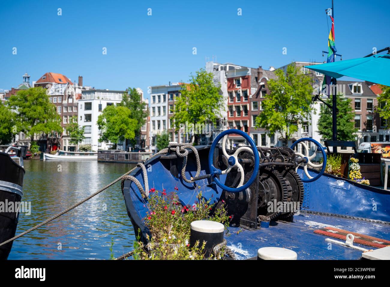 Barche ed edifici sulle rive del fiume Amstel ad Amsterdam, Paesi Bassi Foto Stock