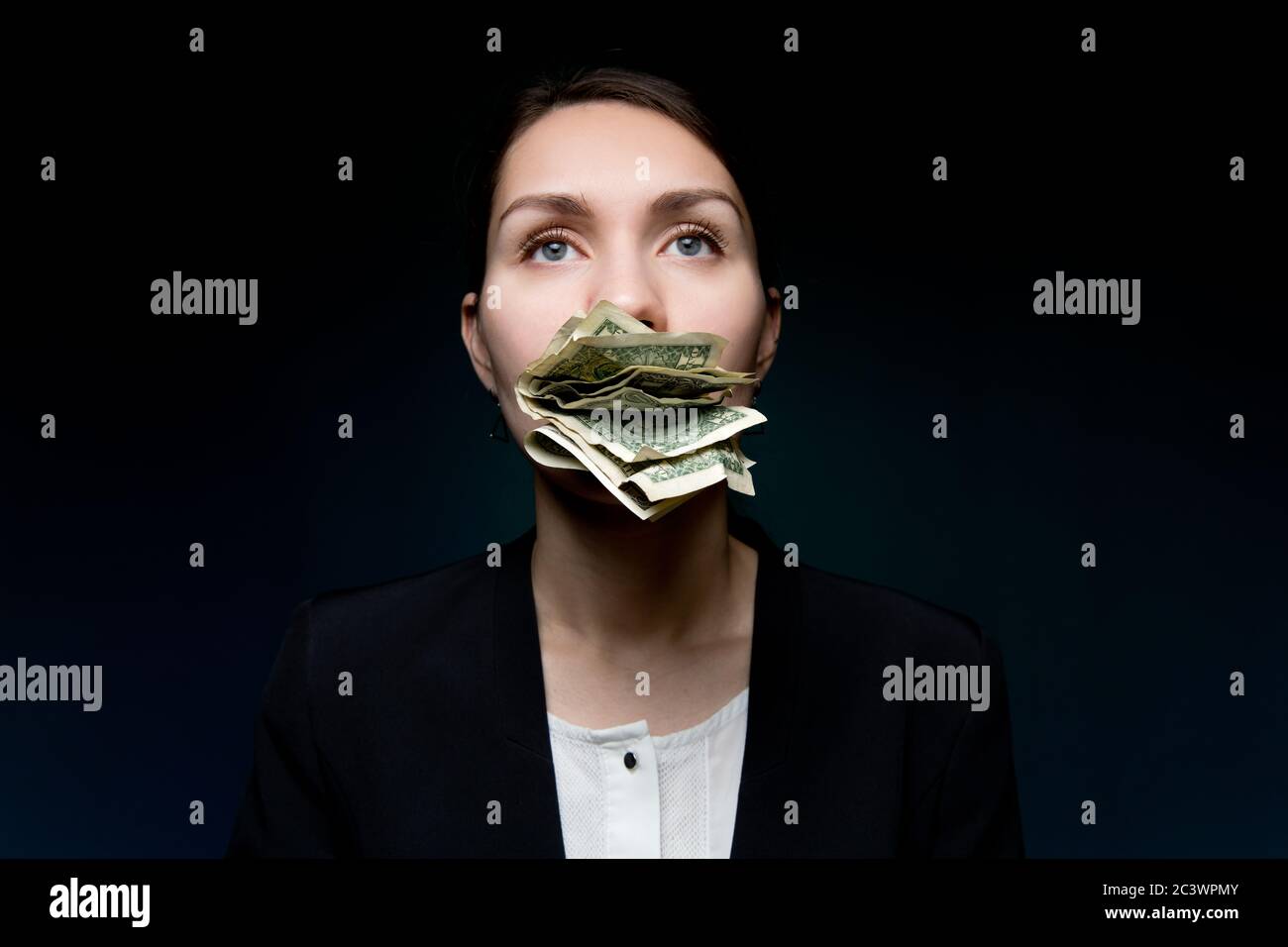 Piccoli soldi in bocca di una donna d'affari, lei è silenziosa a causa del denaro Foto Stock