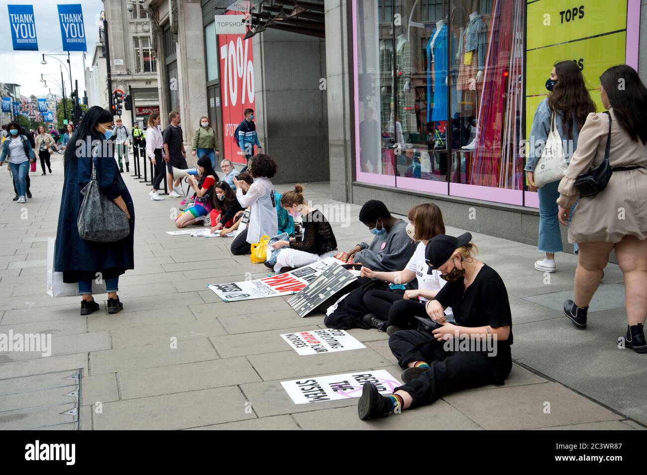 Londra durante la pandemia, giugno 2020. Oxford Street. Riapertura di negozi. Manifestanti da Extinction Rebelion protesta fuori Top Shop contro FAST fa Foto Stock