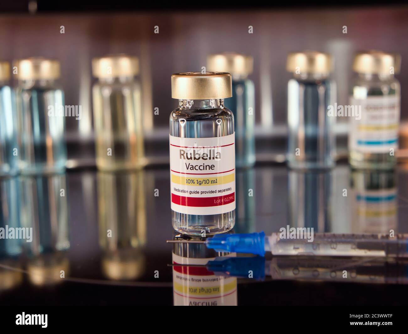 Flaconcino di vaccino contro la rosolia con una siringa su fondo di acciaio inossidabile. Foto Stock