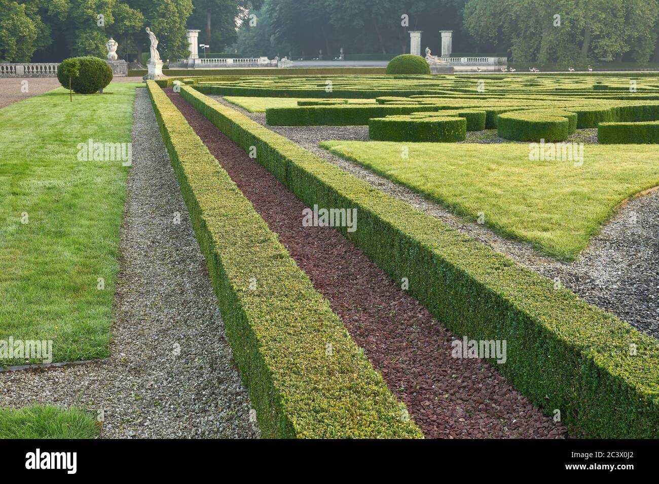 Nordkirchen, Renania Settentrionale-Vestfalia, Germania. 06-20-2020. Castello di Nordkirchen. Bosso ornamentale e sculture storiche nel giardino barocco. Foto Stock