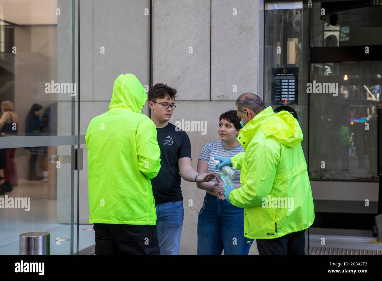 Covid 19 e il negozio di punta Apple a Sydney, il personale addetto alla sicurezza controlla la temperatura e la salute dei clienti che consegnano le maschere per entrare nel negozio Foto Stock