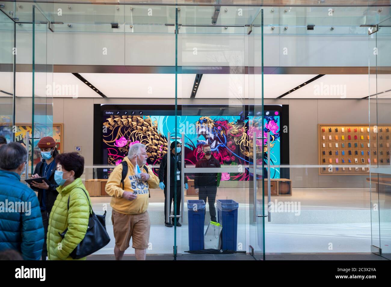 Covid 19 e il negozio di punta Apple a Sydney, il personale addetto alla sicurezza controlla la temperatura e la salute dei clienti che consegnano le maschere per entrare nel negozio Foto Stock