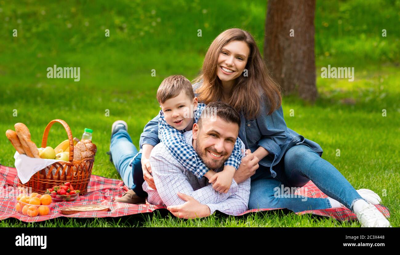 Buona famiglia al picnic. Mamma e papà con il loro figlio che trascorrono il tempo insieme nella foresta Foto Stock