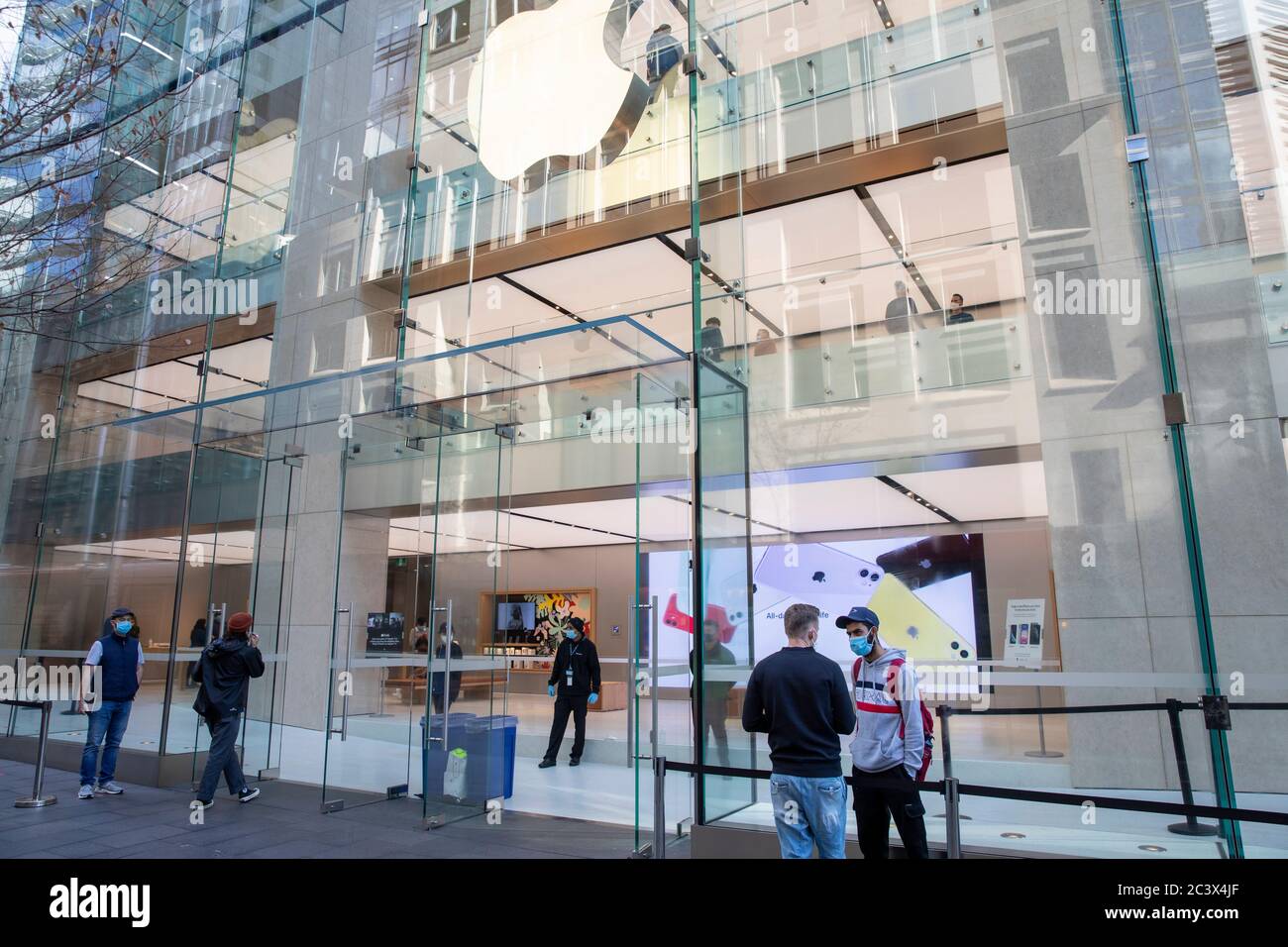 Covid 19 e il negozio di punta Apple a Sydney, il personale addetto alla sicurezza controlla la temperatura e la salute dei clienti che consegnano le maschere per entrare nel negozio Foto Stock