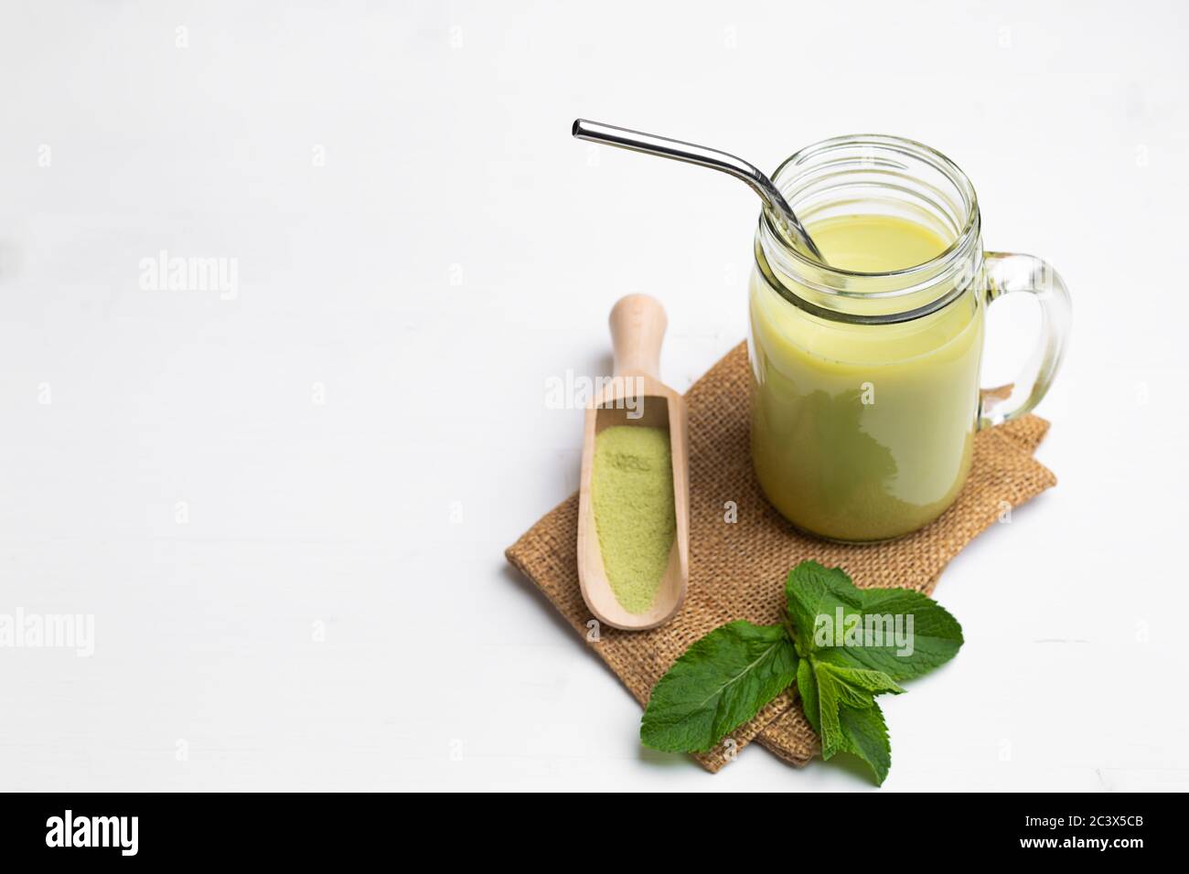Latte Matcha con latte di cocco in vetro vaso su sfondo bianco Foto Stock