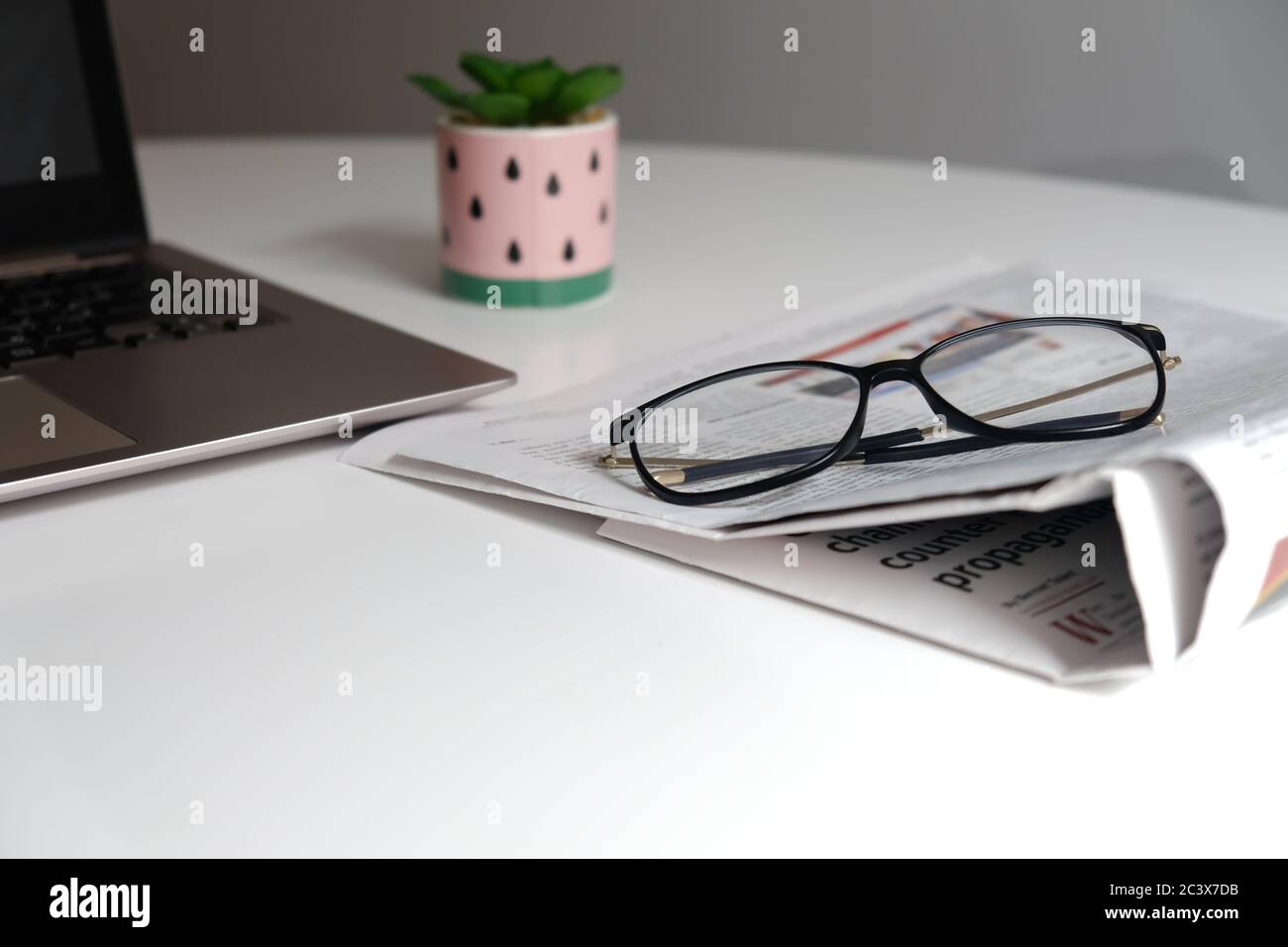 Spazio di lavoro per l'ufficio domestico per l'isolamento. Luogo di apprendimento per la casa o il luogo di lavoro per freelance. Scrivania bianca con spazio vuoto. Giornali e bicchieri. Foto Stock