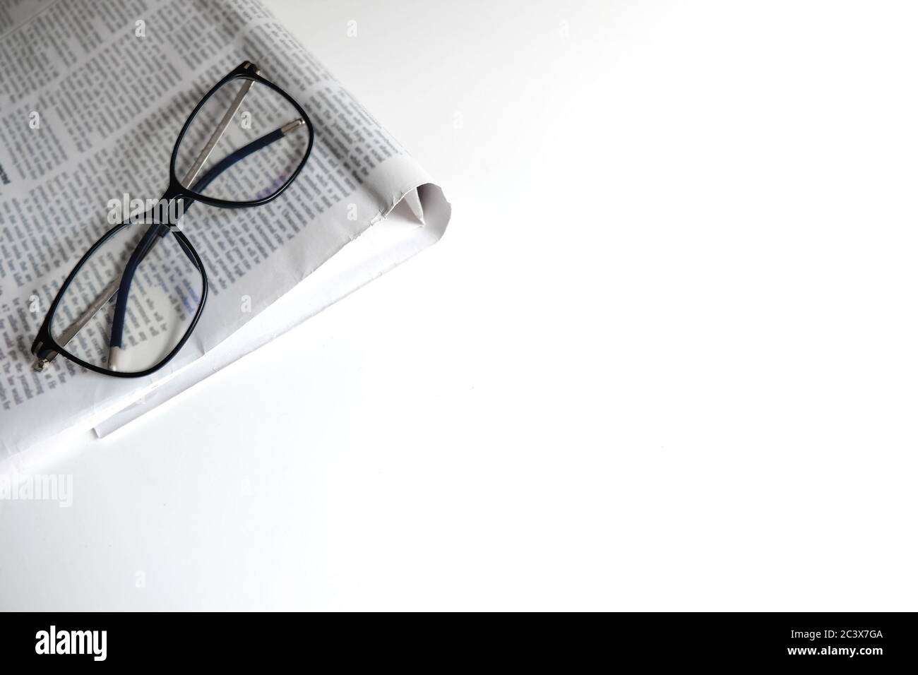 Lettura nell'area di lavoro di isolamento dell'ufficio domestico. Luogo di apprendimento per la casa o il luogo di lavoro per un freelance. Flatlay giornale e occhiali. Foto Stock