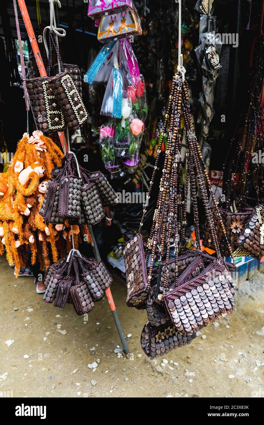 Le borse fatte a mano si trovano in un mercato locale di souvenir vicino alla popolare attrazione turistica Ravana Falls nello Sri Lanka. Vendita di vari accessori colorati Foto Stock