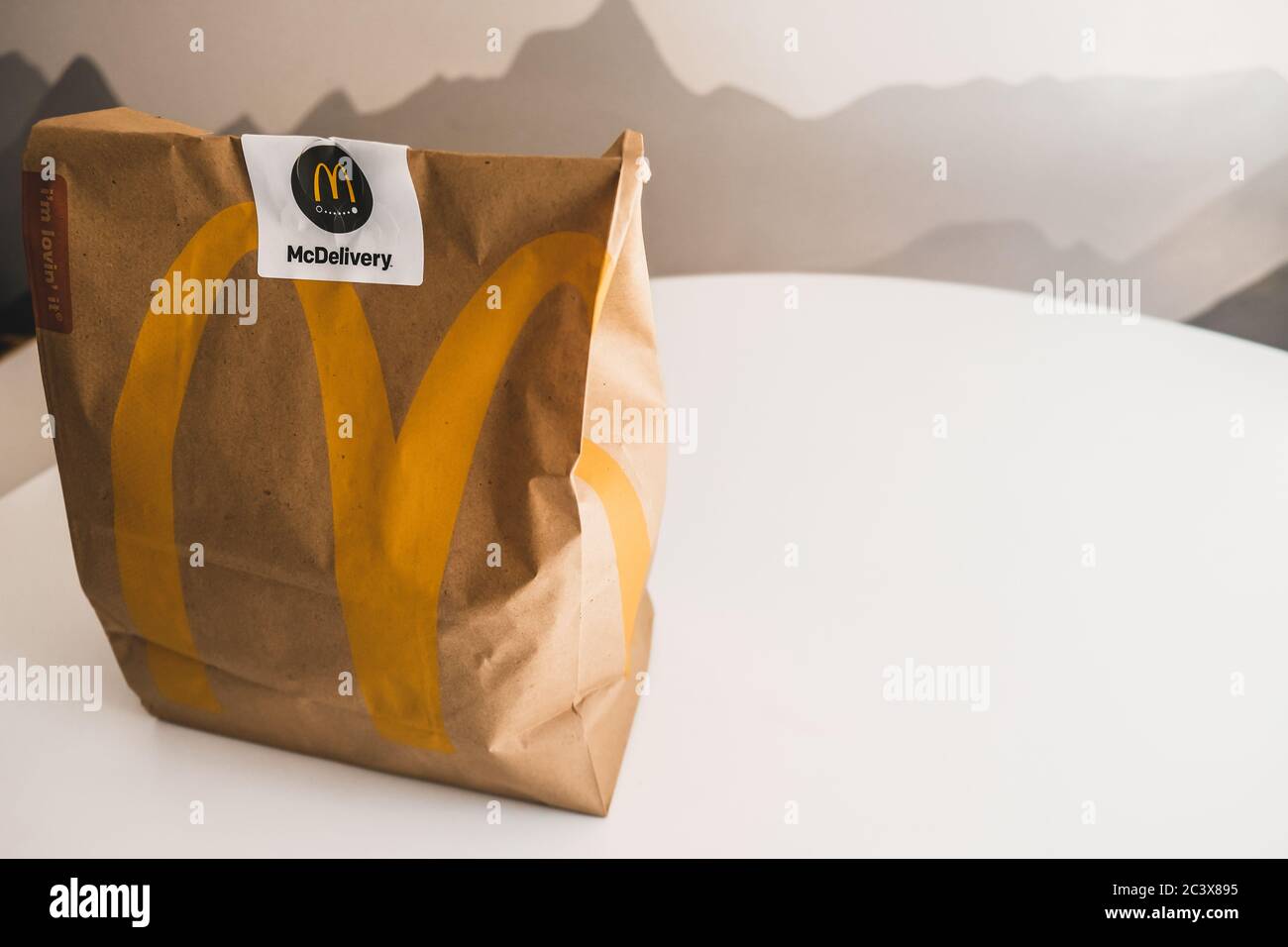 Lviv / Ucraina - Aprile 2020: Alimentazione malsana a casa durante l'isolamento sociale focolaio di coronavirus. Ordinazione di pasti da asporto McDonalds. Sacchetto di carta Foto Stock