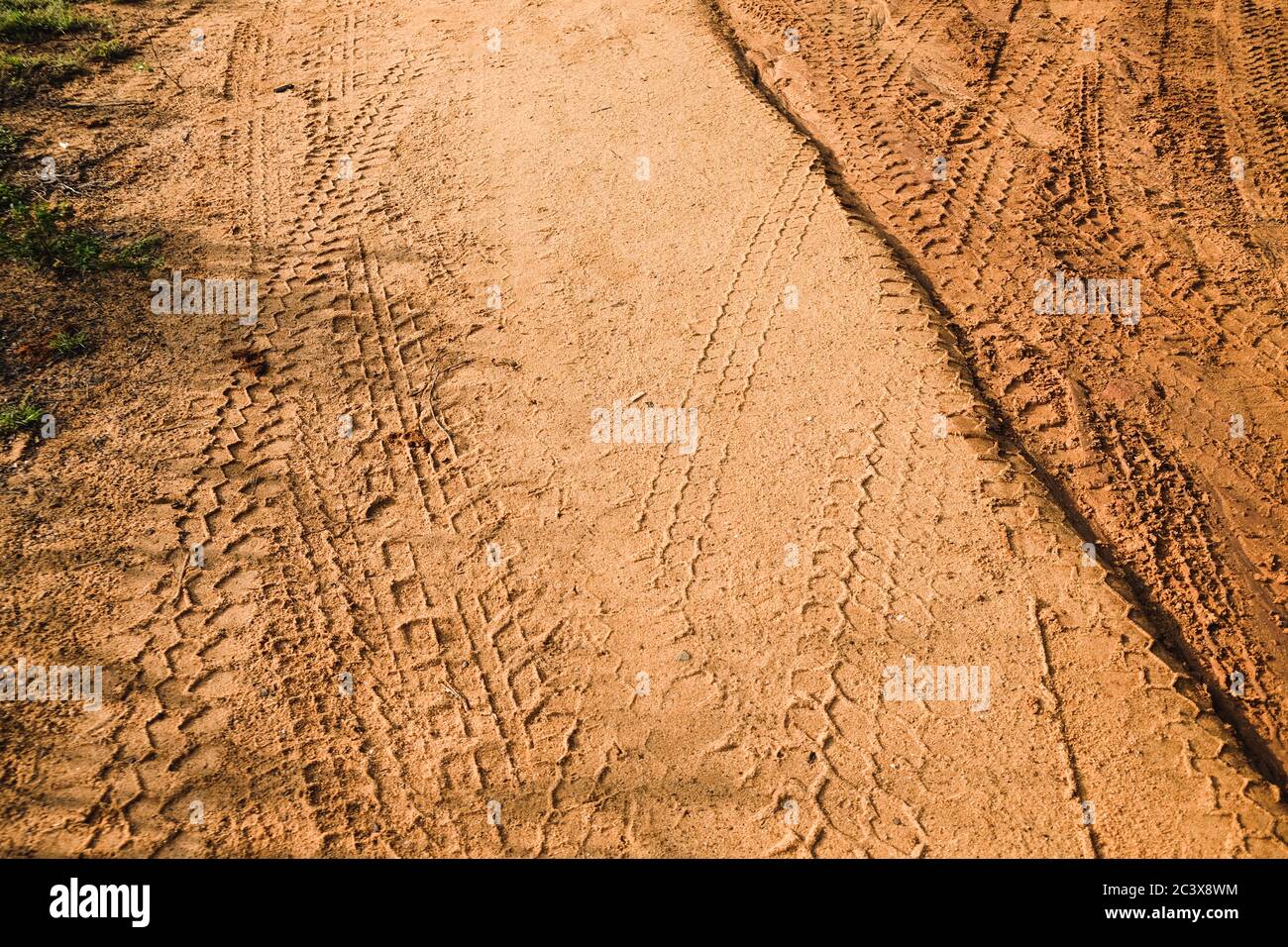 Le tracce di pneumatici sono rimaste dopo un safari in jeep su una strada fangosa. Una texture marrone con una superficie sabbiosa sporca dal Parco Nazionale di Udawalawe, Sri Lanka. Foto Stock