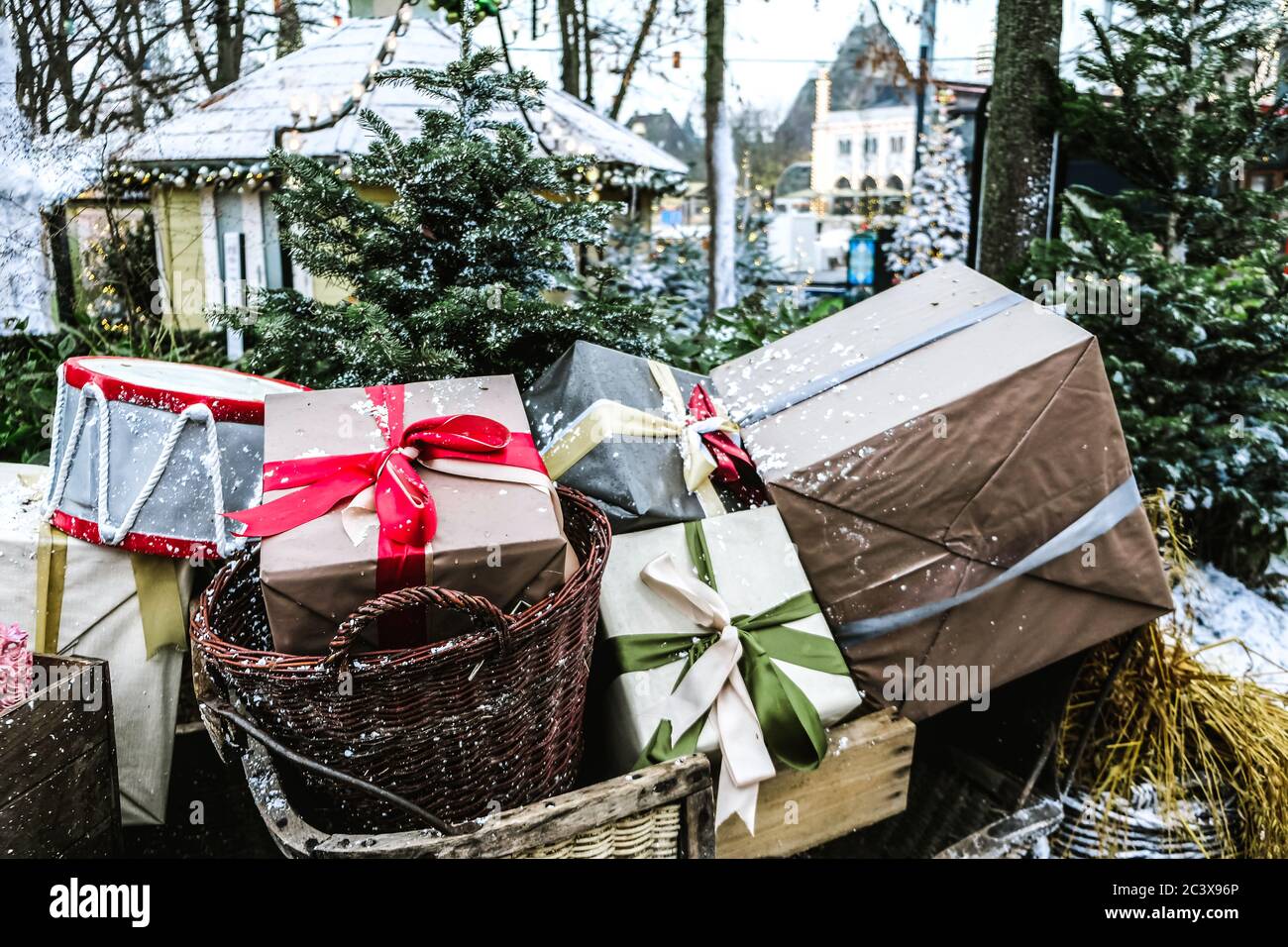 Vista ravvicinata di una slitta Santa piena di confezioni regalo e regali per l'emozione dei bambini. Decorazione divertente del tempo di Natale fuori. Regali di festa confezionati Foto Stock