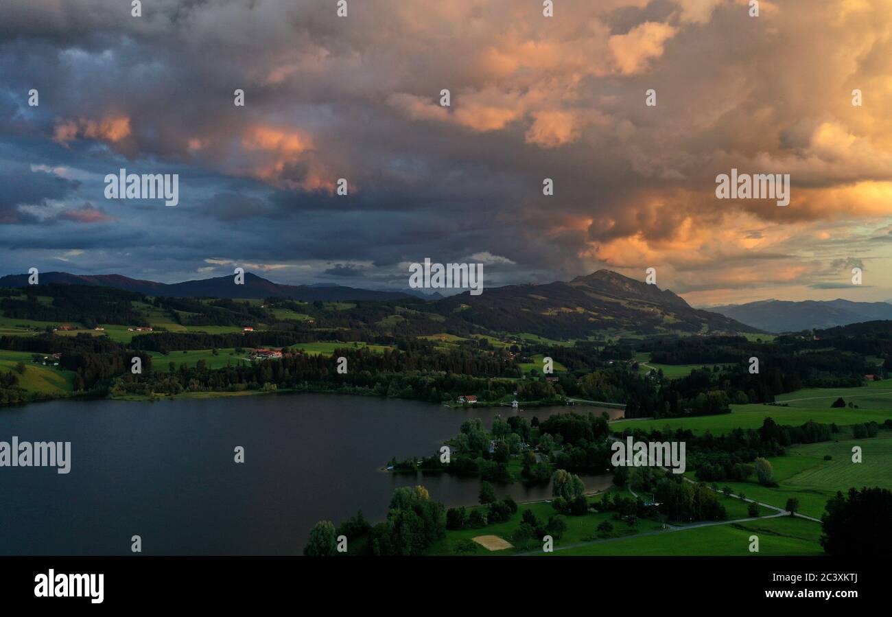 Moosbach, Germania. 22 Giugno 2020. La luce del sole che tramonta colora il cielo sopra il Rottachsee e il Grünten (foto aerea con un drone). Credit: Karl-Josef Hildenbrand/dpa/Alamy Live News Foto Stock