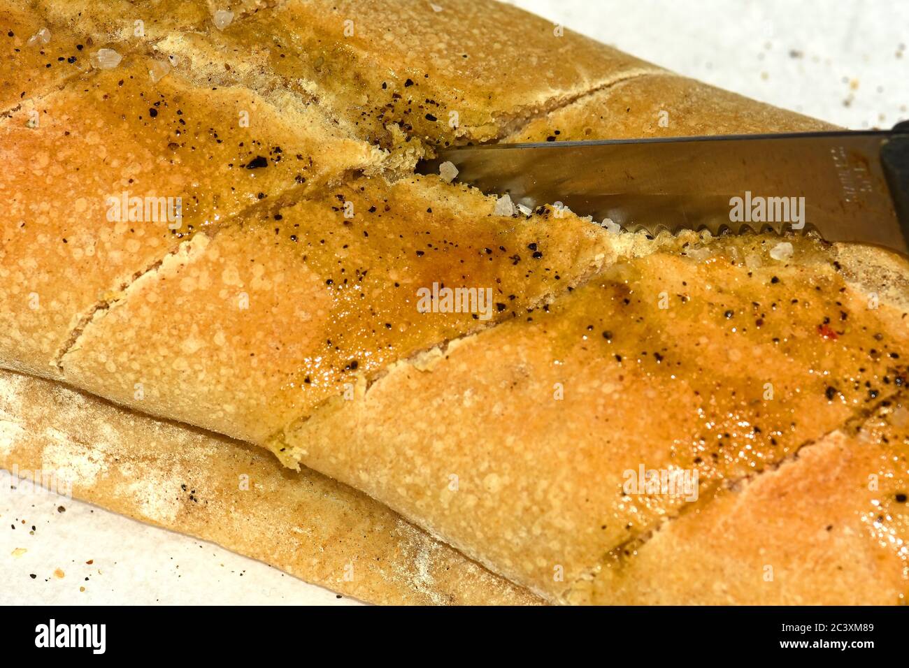 Tagliare il pane di focaccia appena sfornato Foto Stock