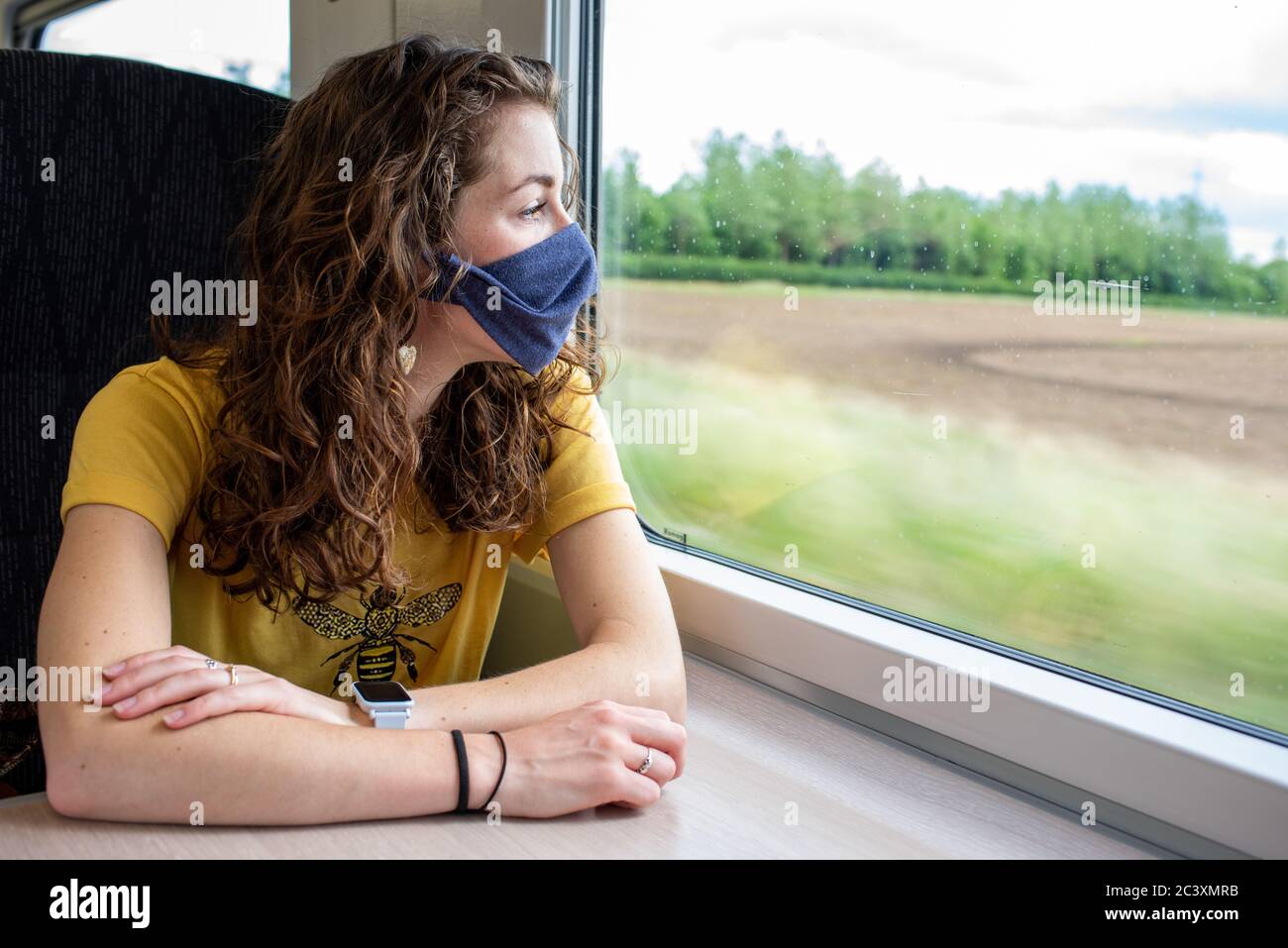 Indossare una maschera sul treno coronavirus uk viaggio ferrovia trasporto pubblico distanza sociale rimanere al sicuro Foto Stock
