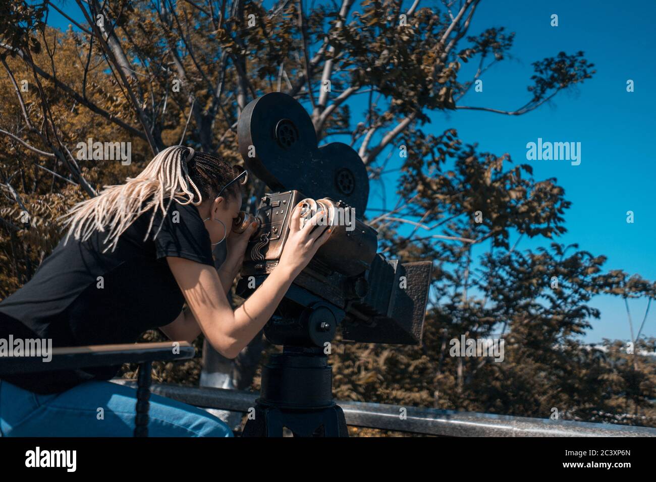 regista femminile che guarda il mirino della fotocamera Foto Stock