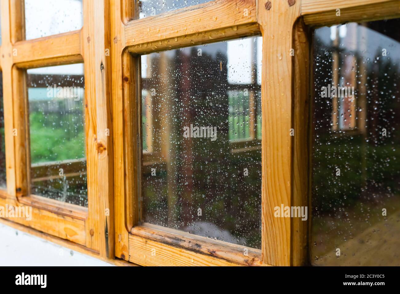 Vecchia finestra di legno d'epoca con gocce d'acqua sul bicchiere dopo la pioggia. Foto Stock