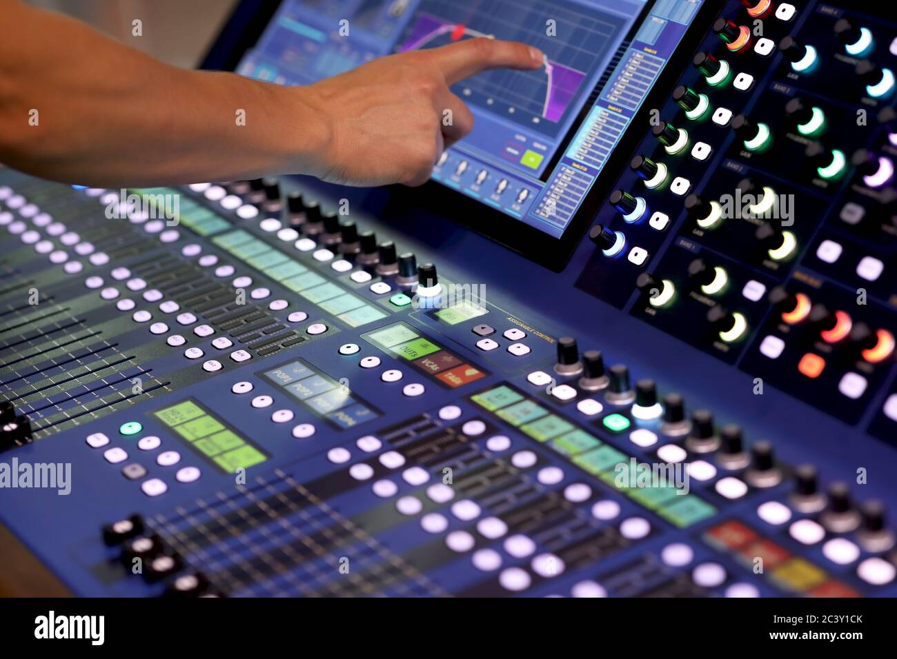 Tecnico del suono che utilizza il touchscreen per controllare la console di mixaggio digitale. Messa a fuoco selettiva. Foto Stock