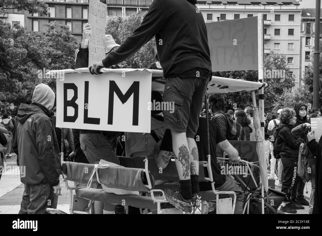 Manifestanti su un risciò con la bandiera di BLM durante l'assemblea di protesta in solidarietà al movimento Black Lives Matter alla stazione centrale di Milano. Foto Stock